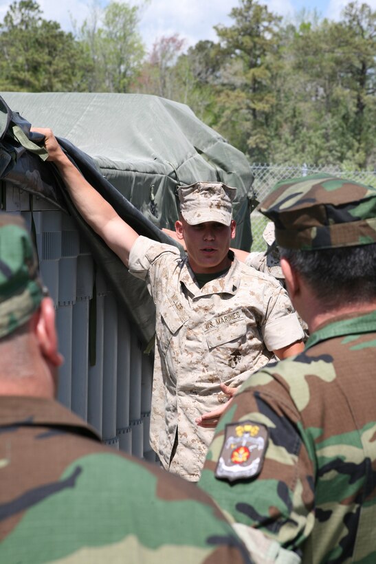 Cpl. Joshua Miller, a water support technician with 8th Engineer Support Battalion, Combat Logistics Regiment 25, 2nd Marine Logistics Group, explains how the water purification system functions aboard Camp Lejeune, N.C., April 8, 2010. The Argentine Marines visited II Marine Expeditionary Force units as part of a theatre engagement program designed to improve military relationships around the world.