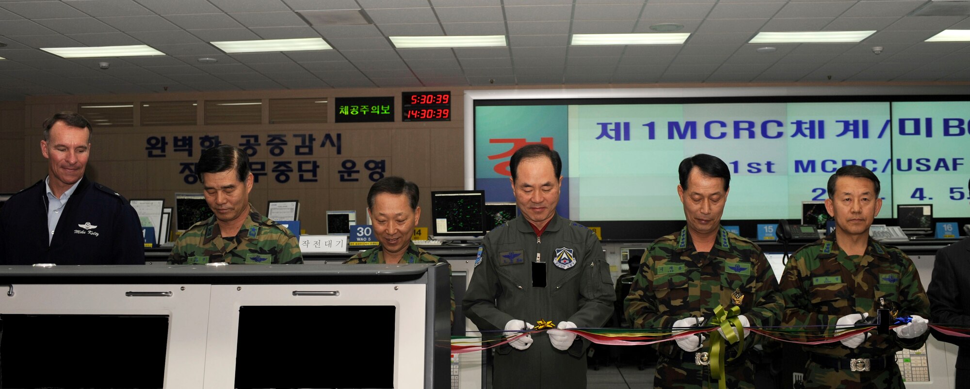 Republic of Korea Air Force and U.S. Air Force officials participate in a ribbon-cutting ceremony April 5, commemorating full operational capability of combined operations for ROKAF's 31st Master Control and Reporting Center and the U.S. Air Force's 621st Air Control Squadron at Osan Air Base, Republic of Korea. Over the last year, the 621st ACS completed an extensive relocation project to combine command and control operations on the same control floor with the ROKAF control system at Osan's Hardened Theater Air Control Center. This move improved coordination between controllers, enhanced combined operations, and ensured flight safety on the Korean Peninsula. (U.S. Air Force photo/Staff Sgt. Stephenie Wade)