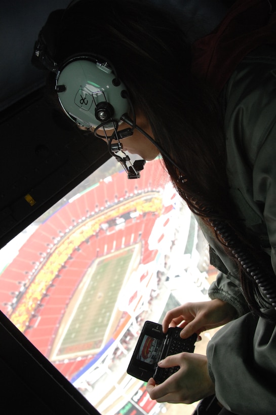 Michele, a Washington Redskins cheerleader, snaps a photo of FedEx Field, home of the Redskins, while on an incentive flight on board a 1st Helicopter Squadron UH-1N Huey March 26. She and fellow Redskinettes Lee-Ann and Sabrina later had lunch with Airmen at the Freedom Hall Dining Facility, signed autographs, and took part in the first-ever Joint Team Andrews Award Ceremony in the Base Theater. (U.S. Air Force photo by Staff Sgt. Christopher Marasky)