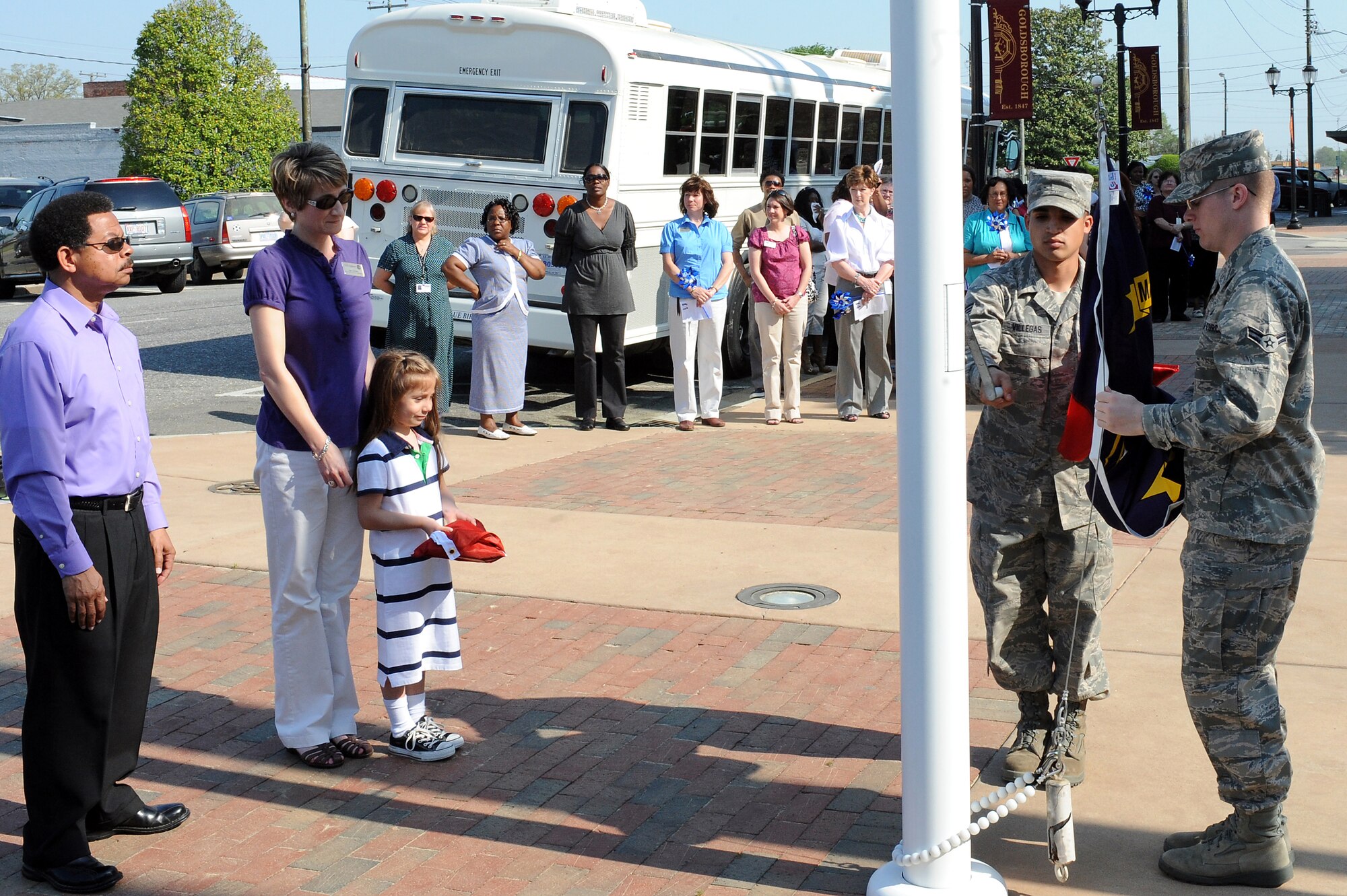 GOLDSBORO, N.C. -- (right to left) Airman 1st Class Charles Rodriguez and Senior Airman Carlos Villegas prepare to raise the North Carolina flag during the Child Abuse Prevention Month proclamation ceremony at City Hall in downtown Goldsboro, April 6, 2010.  Airmen Rodriguez and Villegas also raised the Child Abuse Prevention Month flag to be flown for 30 days.  Airman Rodriguez, from Spencer, Ohio, and Airman Villegas, from York, Pa., are both ceremonial guardsmen assigned to the 4th Fighter Wing Honor Guard.  (U.S. Air Force photo/Master Sgt. Brandt Smith)