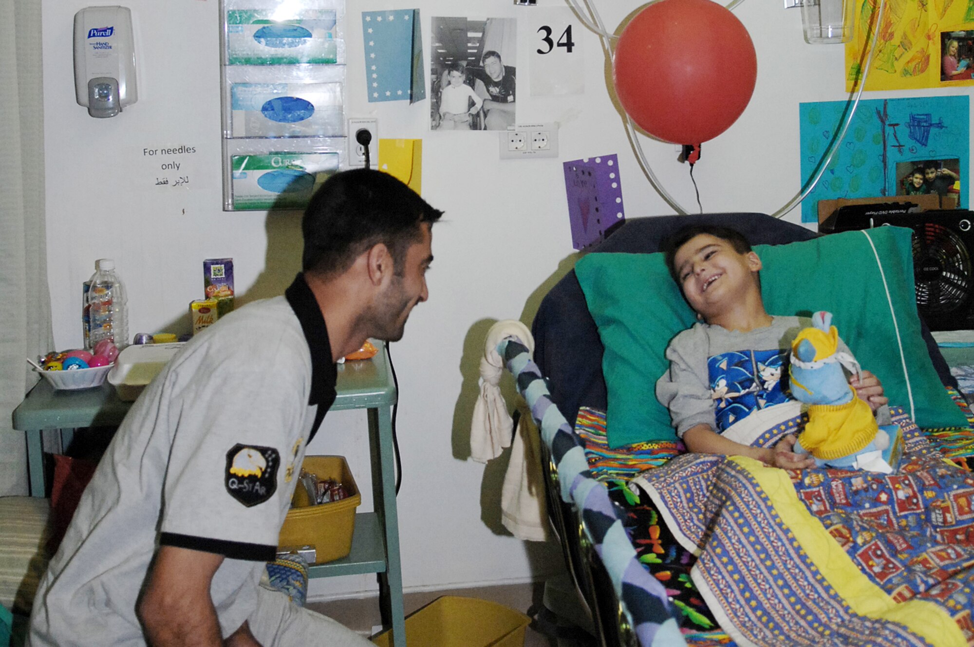 Six-year-old Sajad Hany Shaker Mahmud, a survivor of an improvised explosive device attack, plays with a birthday gift with his father as they celebrate his 6th birthday while recovering April 1, 2010, at the Air Force Theater Hospital in Iraq. Sajad received multiple presents and birthday wishes from the medical staff who have taken care of him during his 72-day stay at the hospital. (U.S. Air Force photo/Airman 1st Class Allison M. Boehm)