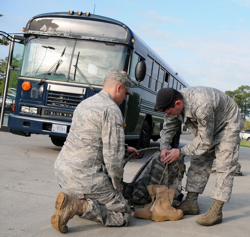 Tech. Sgt. Jeremy Klemme assists Airman Joshua Cook with securing his boots to his rucksack before departing for deployment training April 8, 2010, at Joint Base Charleston, S.C. Airman Cook, along with approximately 30 Airman with the 628th Security Forces Squadron, prepared for two weeks to depart on a short-notice deployment tasking to stand up defenses at a bare-base location in the Middle East. Sergeant Klemme is the unit deployment manager for the 628 SFS, and Airman Cook is an installation entry controller with the 628 SFS. (U.S. Air Force photo/Staff Sgt. Daniel Bowles)
