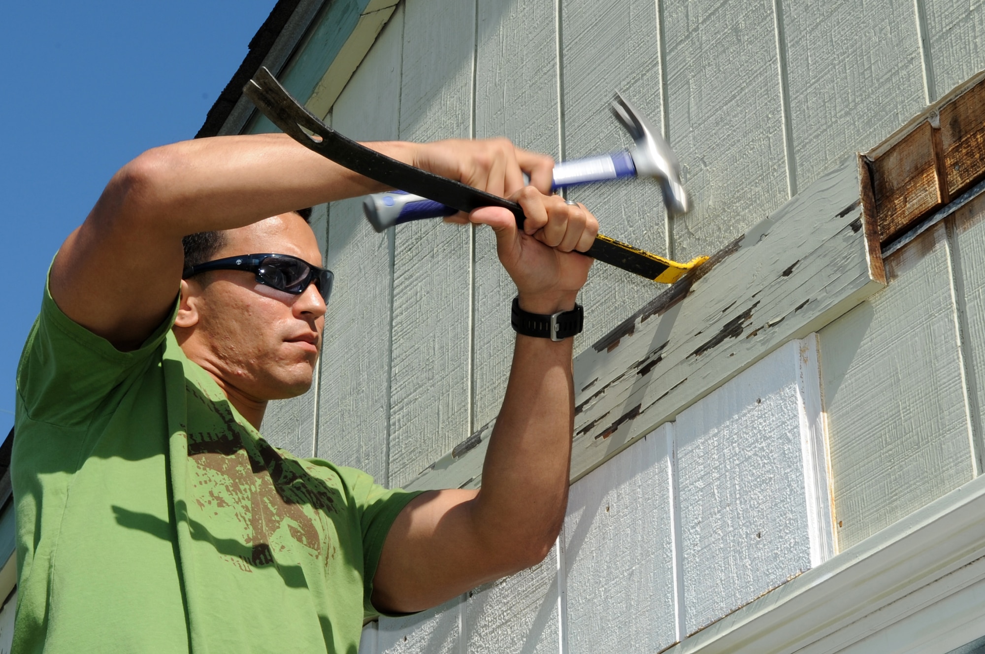 FORT FISHER RECREATION AREA, N.C. -- 2nd Lt. Ralph Soto uses a crow bar to remove weathered wood from a cottage here, April 7, 2010. Airmen from Seymour Johnson Air Force Base volunteered to help replace the siding of cottages here to save money. Lieutenant Soto, 4th Comptroller Squadron financial services flight officer, hails from Chicago. (U.S. Air Force photo/Staff Sergeant Courtney Richardson)