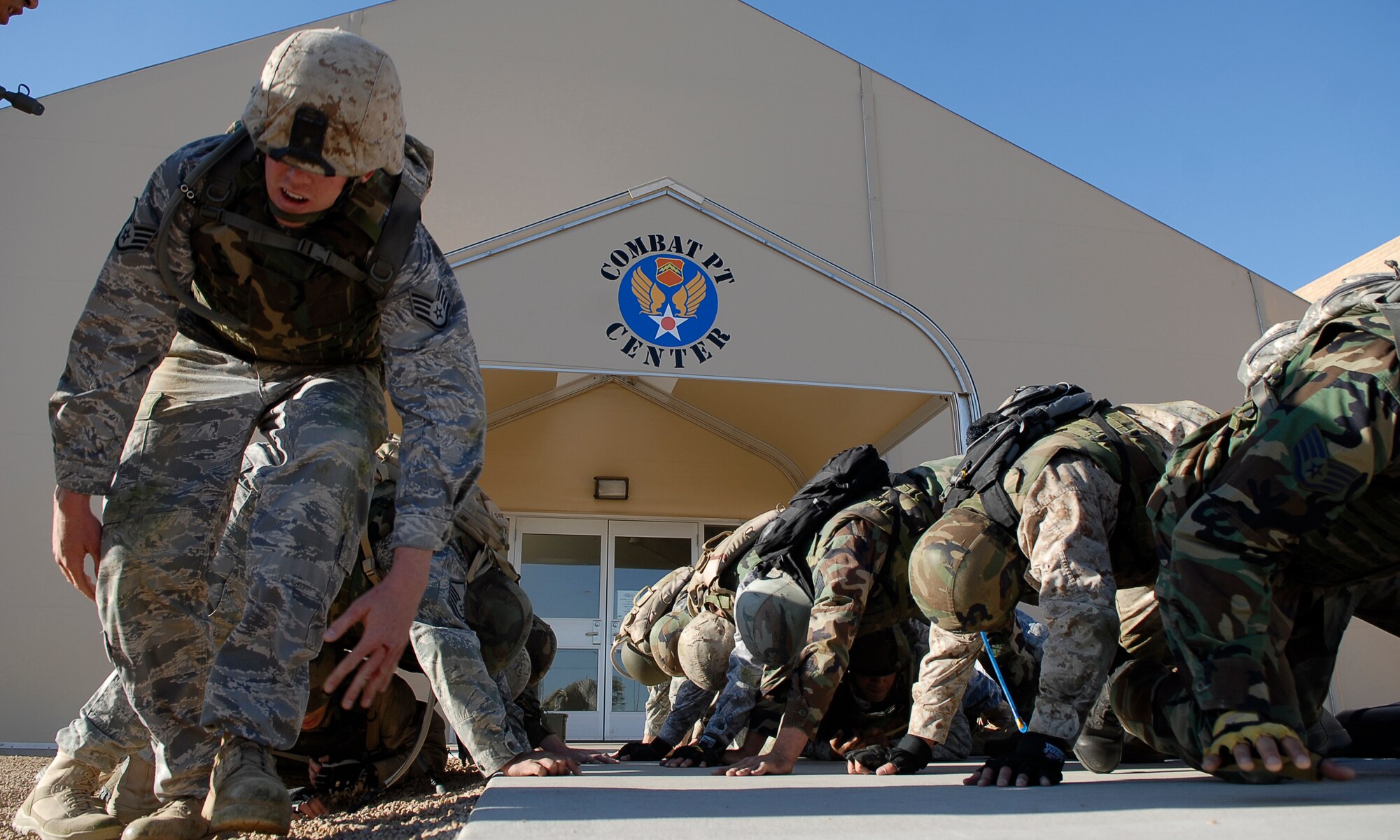 Staff Sgt. Ryan Cobb, left, 56th Communications Squadron airfield systems technician, positions himself to continue "building a house." This event involves squad team members contructing a human-made tunnel allowing team members to crawl underneath one another as conditioning for a military combative training course held at the Combat PT Center, Luke Air Force Base, Ariz., April 7.  (U.S. Air Force photo by Airman 1st Class Ronifel Yasay)