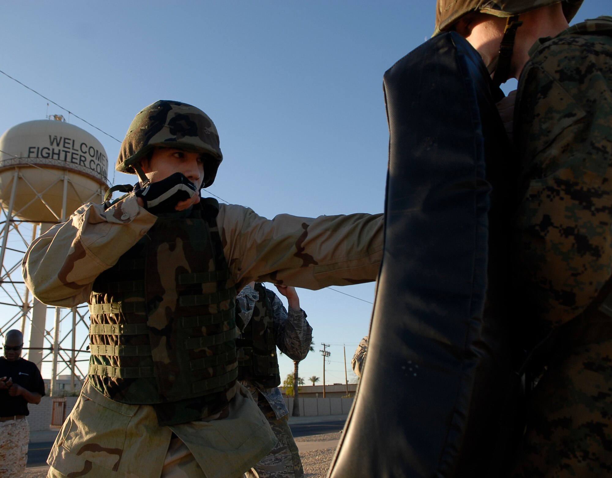 Matthew Corcoran, left, 56th Force Support Squadron CrossFit Luke group instructor, punches a combat pad held by U.S. Marine Corp. Lance Cpl. Jay Clayton, Bulk Fuel Co. C, 6th Engineer Support Battalion, during their military combative training course at Luke Air Force Base, Ariz., April 7. Participants of the course ran around Luke stopping periodically to practice the techniques they learned.  (U.S. Air Force photo by Airman 1st Class Ronifel Yasay)