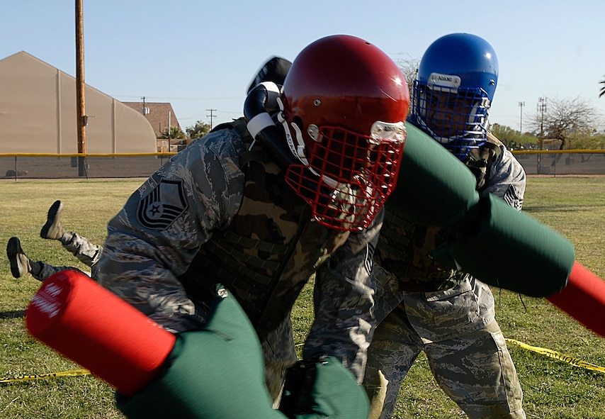 Master Sgt. Glen Presswood, left, 61st Aircraft Maintenance Unit support flight chief, receives a pugil stick hit from Staff Sgt. Jesus Artesi, 56th Medical Support Squadron information technology specialist, during a military combative training course taught by U.S. Marine Corp. Staff Sgt. Gardy Sylvain, Training chief staff NCO, on the softball field of Luke Air Force Base, Ariz., April 6. The combative training course began April 1st and will continue until April 23rd.  (U.S. Air Force photo by Airman 1st Class Ronifel Yasay)