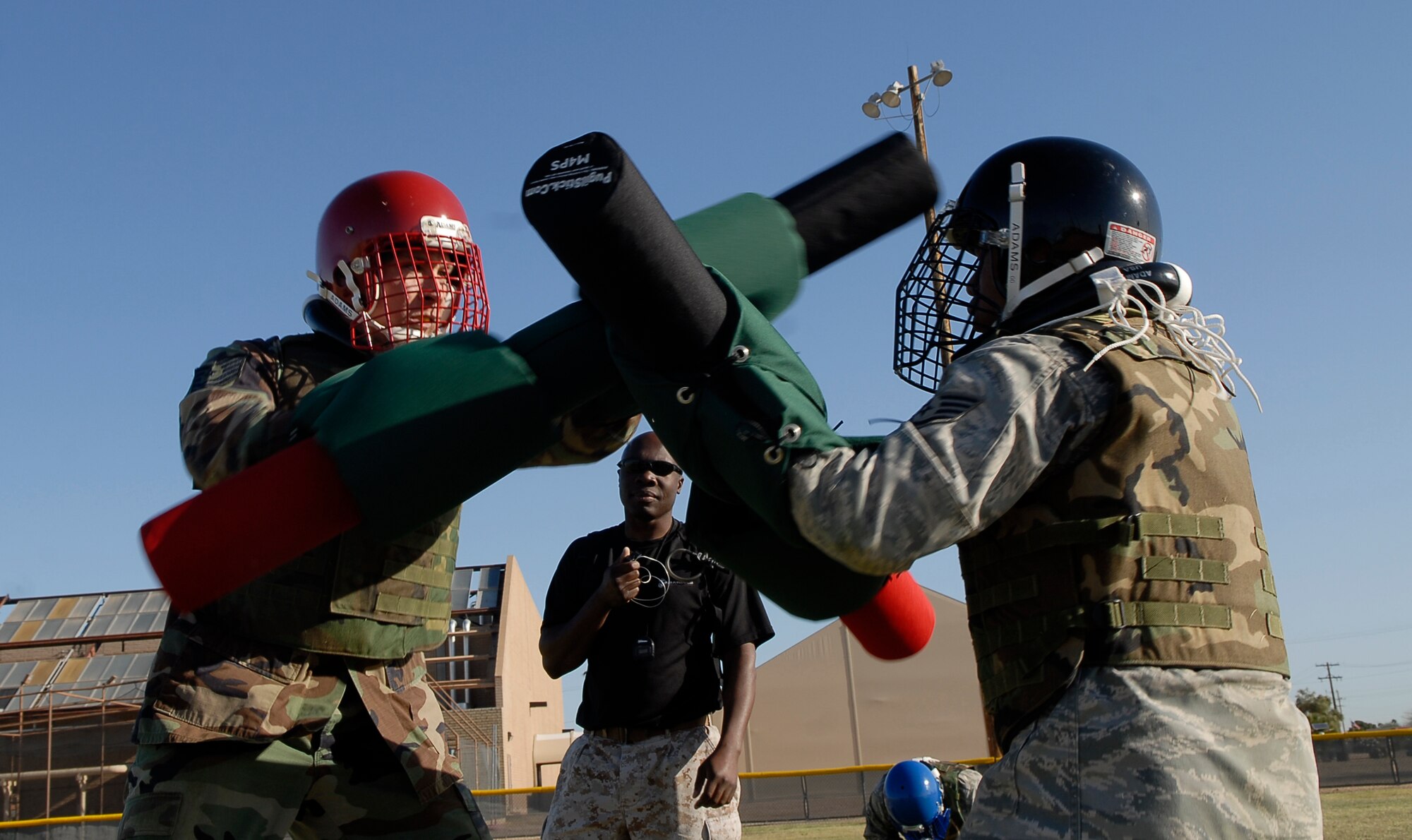 Tech. Sgt. Shannon Wood, 372nd Training Squadron Detachment 12 production supervisor, delivers a blow with his pugil stick to Staff Sgt. Anthony Cubillo, 56th Maintenance Operations Squadron weapons systems coordinator, during a military combative training course taught by U.S. Marine Corp. Staff Sgt. Gardy Sylvain, Training chief staff NCO, at the base softball field on Luke Air Force Base, Ariz., April 6. The course started April 1 and will continue until April 23. Participants will have an opportunity to earn a green belt by the end of the course.  (U.S. Air Force photo by Airman 1st Class Ronifel Yasay)