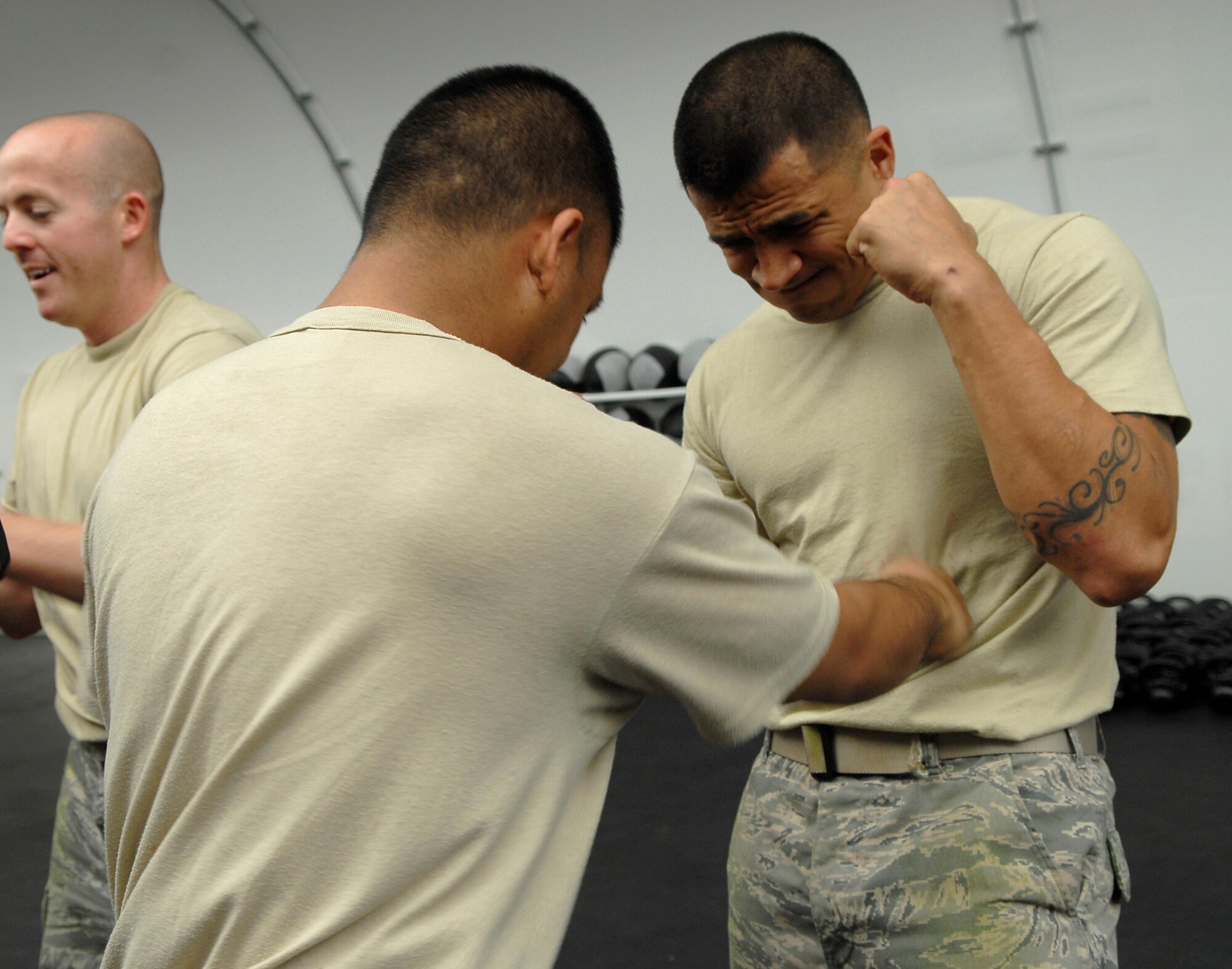 Staff Sgt. Paul Amasol, 56th Communications Squadron airfield systems technician, punches Staff Sgt. Abel Telles, 56th Logistics Readiness Squadron fuels specialist, in his stomach during a military combative course held at the Combat PT Center at Luke Air Force Base, Ariz., April 5. This session of the training course is called "body hardening" in which one allows the body to adjust to getting hit.  (U.S. Air Force photo by Airman 1st Class Ronifel Yasay)