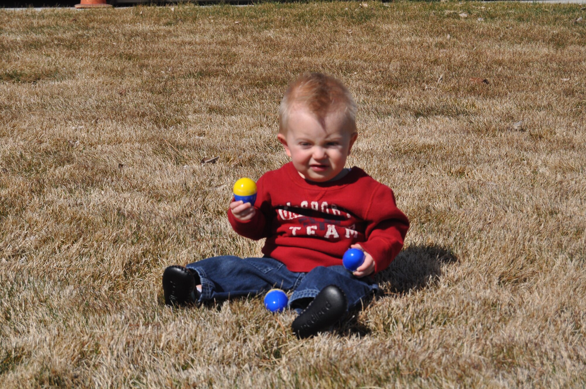 Oliver Bird, son of Master Sgt. Nathan Bird, 151st Logistics Readiness Squadron, finds an Easter egg during the Utah Air National Guard's annual Children's Easter Egg Hunt March 27. Oliver was one of hundreds of children who participated in the festivities on base, which included a magic show, egg hunt and hot dog lunch. U.S. Air Force photo by Lindsey Cheetham.