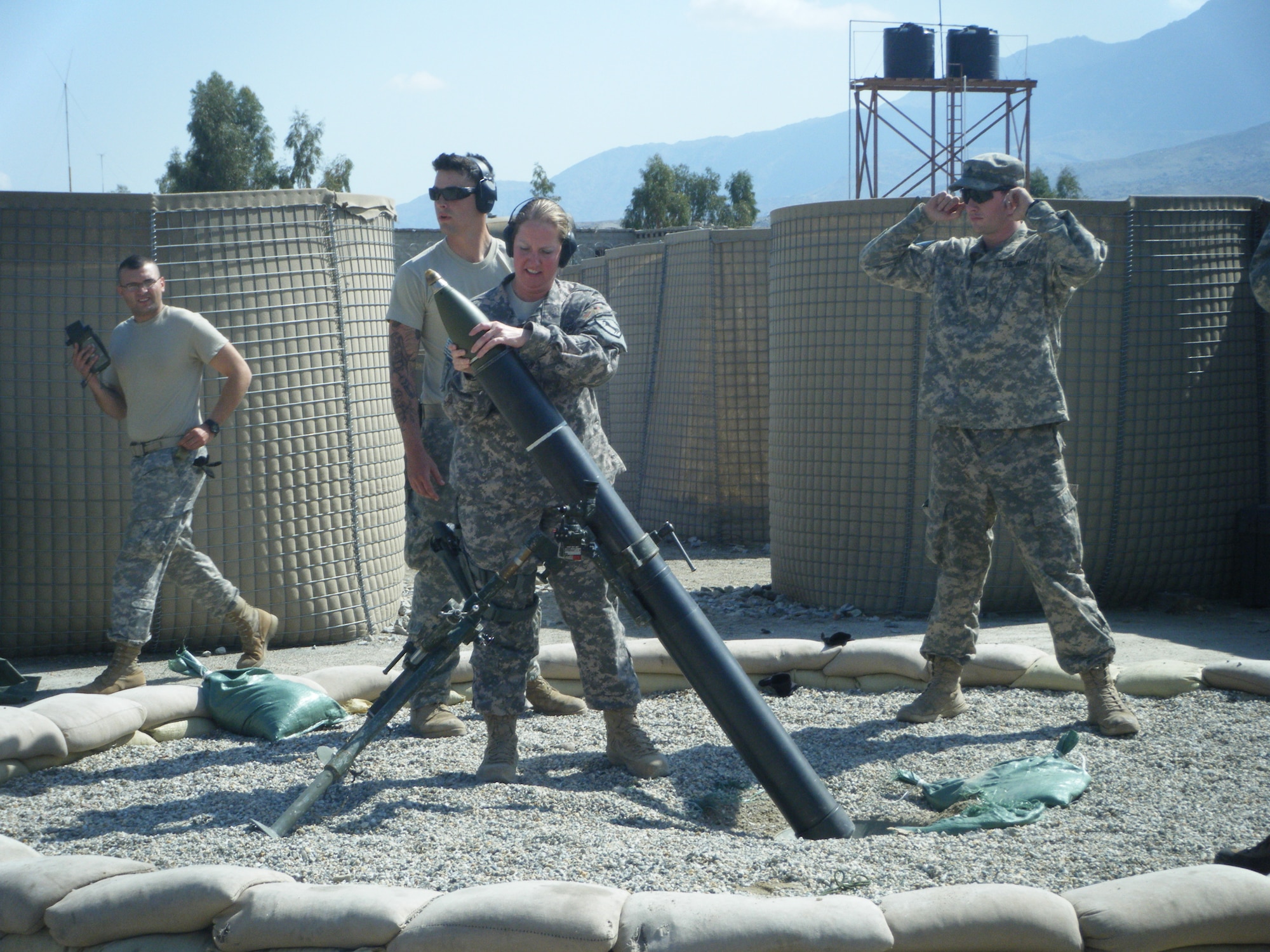 FORWARD OPERATING BASE MEHTAR LAM, Afghanistan -- Staff Sgt. Jessica Williams, 633d Medical Group Mental Health Flight, loads a mortar in preparation for a launch. WIlliams is currently deployed to Afghanistan, serving in combat stress care. (Courtesy photo)