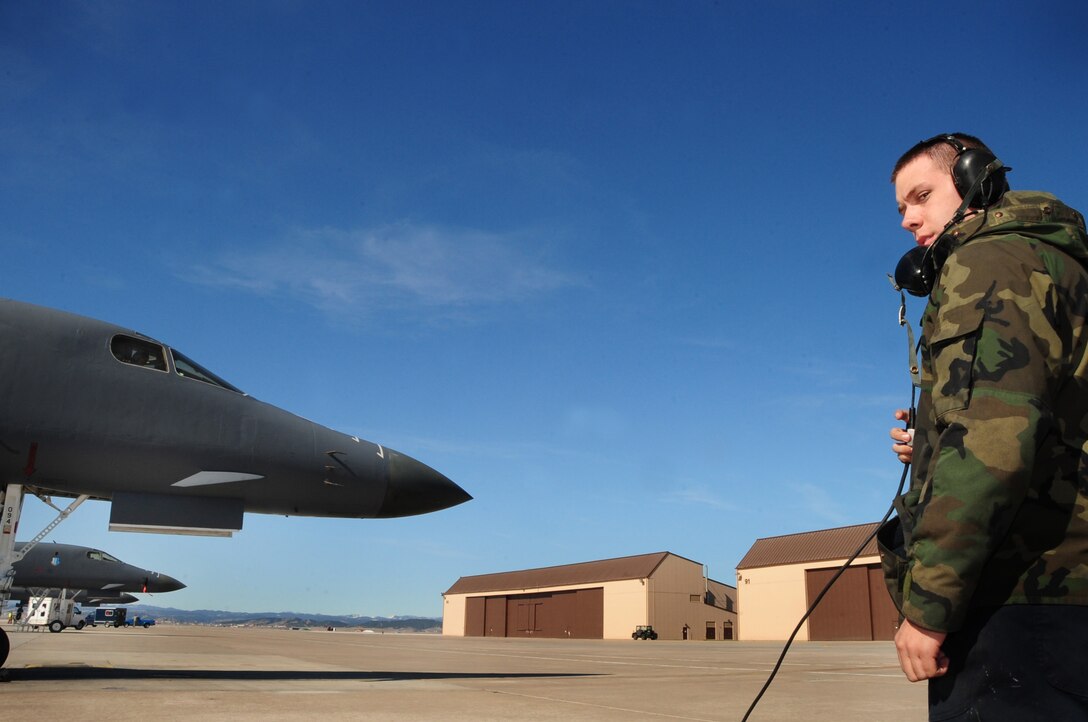 ELLSWORTH AIR FORCE BASE, S.D. -- Airman 1st Class Jeremiah Hand, 28th Aircraft Maintenance Squadron crew chief, speaks with pilots using a communication cord head set before they take off.  The B-1B Lancer can rapidly deliver massive quantities of precision and non-precision weapons against any adversary, anywhere in the world, at any time. (U.S. Air Force photo/Airman 1st Class Anthony Sanchelli)
