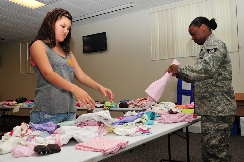 Airman 1st Class Mindy Park and Staff Sgt. Jessica May of the 45th Logistics Readiness Flight organize donated clothing at the Second Annual Kids Fair and Kiddy Clothing Swap at the Shark Center April 2. Children of all ages came out to have fun and learn about Patrick Air Force Base and parents were able to donate un-needed clothing and swap it for new. (U.S. Air Force photo/Jennifer Macklin)