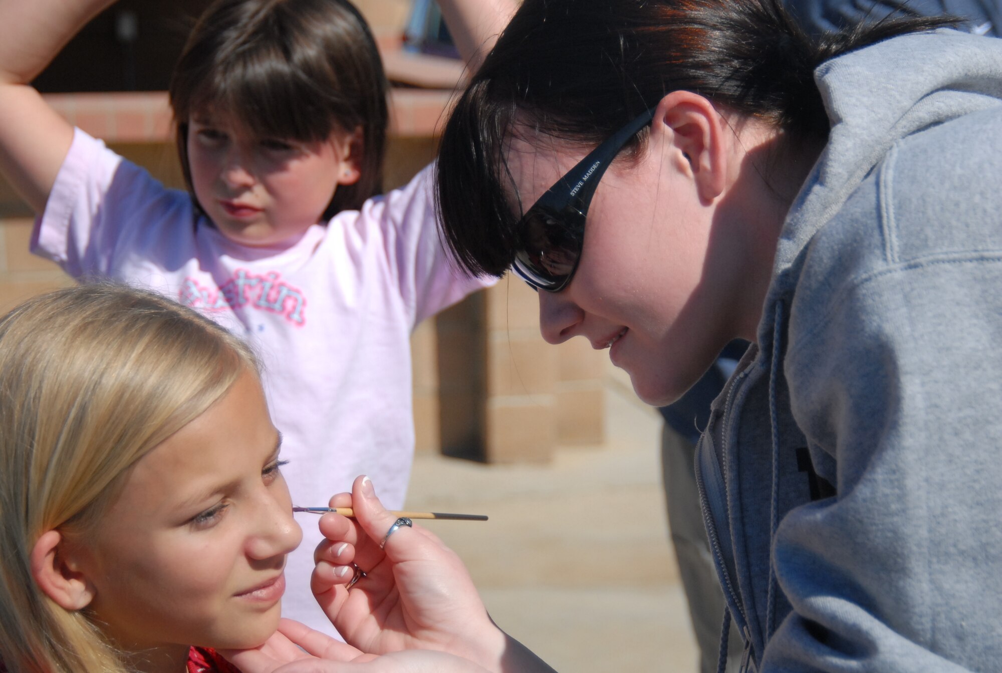 Maggie Edwards gets here face painted by Airman Abigail Diaz, 412th Test Wing, Operations Support Squadron, during kick-off activities to National Child Abuse Prevention Month at Arnold Park, here, April 1st.  Air Force photograph by Stephen K. Robinson