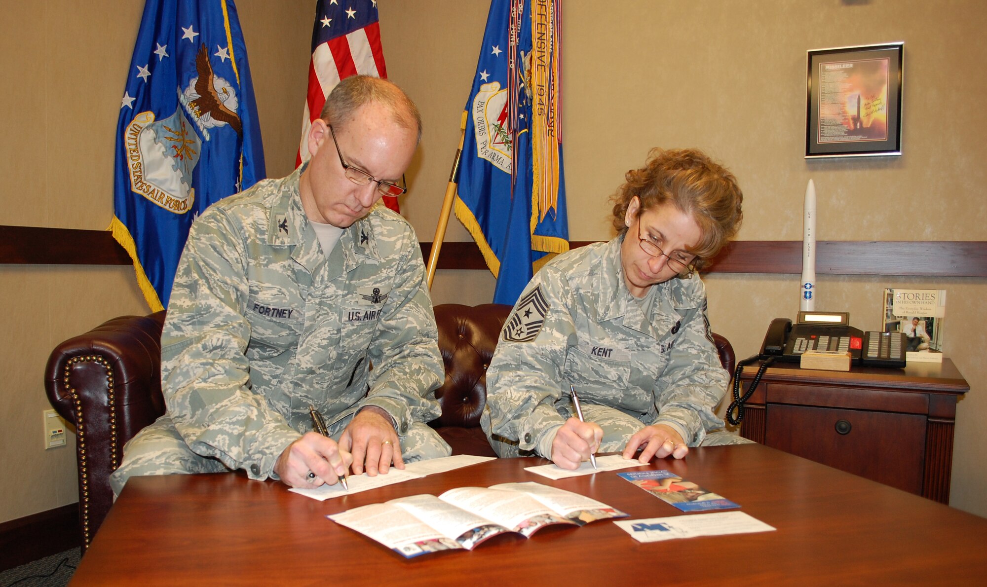 Col. Michael Fortney, 341st Missile Wing commander, and Chief Master Sgt. Cari Kent, 341st MW command chief, fill out their pledge forms to contribute to this year's Air Force Assistance Fund. The annual campaign kicked off March 29 and runs through May 7. See your squadron representative to donate. (U.S. Air Force photo/Valerie Mullett)