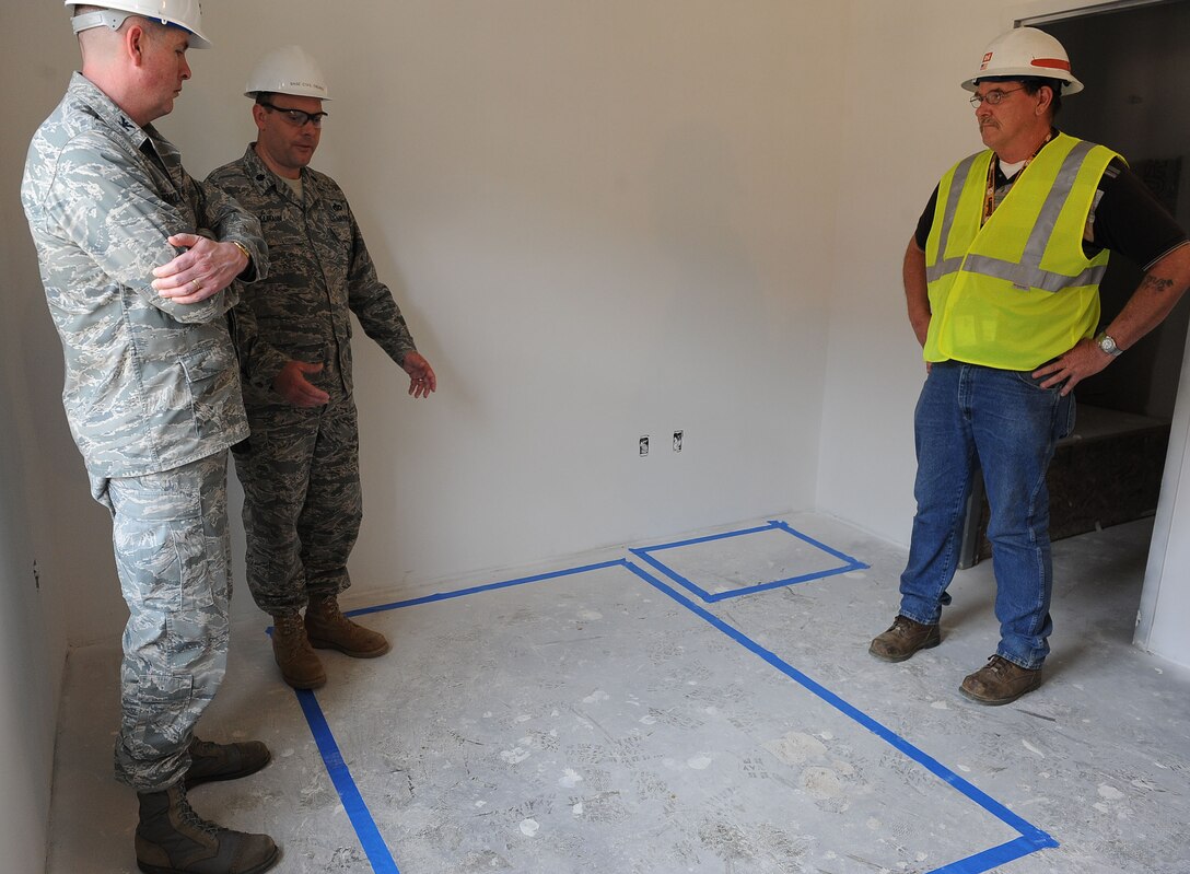 LANGLEY AIR FORCE BASE, Va. -- Col. Donald Kirkland, 633d Air Base Wing commander, and Lt. Col. Jeffery Ullmann, 633 Civil Engineer Squadron commander, discuss furniture floor plans with Paul Petersen, civil engineer contractor, for a future Airman dormitory during the Base Civil Engineer Update Project Tour March 7. 633 CES is constructing and improving multiple facilities base-wide. (U.S. Air Force photo/Airman Rebecca Montez)