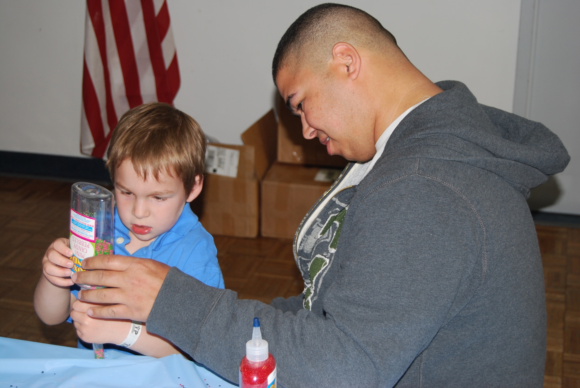 David Burress, 341st Maintenance Operations Squadron technician, helps Nathan, 5, make a rock-candy tube at the Spring Carnival April 3.(U.S. Air Force photo/Airman 1st Class Kristina Overton)