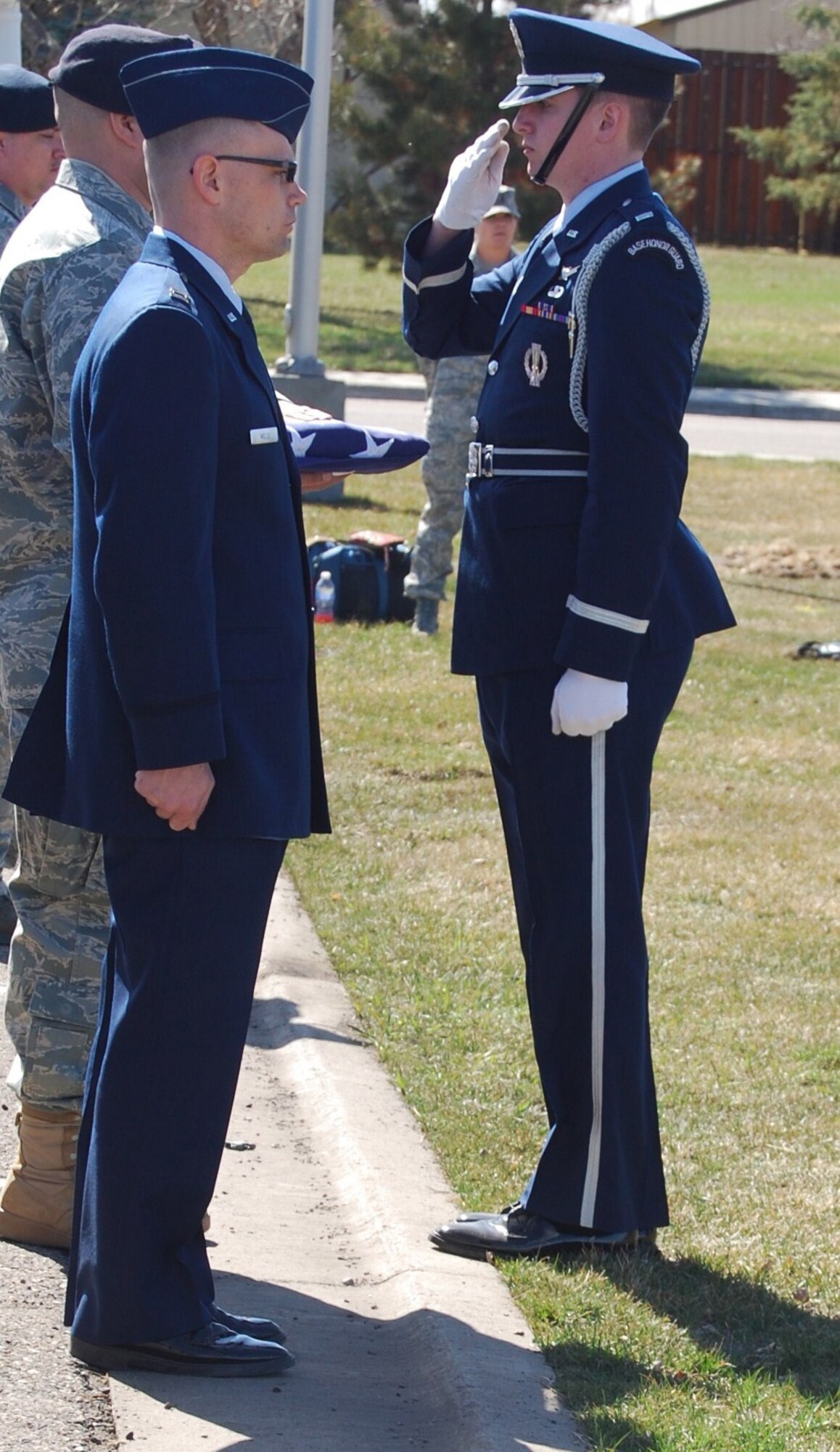 1st Lt. Robert Wray, Honor Guard officer in charge, renders a salute after presenting Tech. Sgt. Rakesh Dewan, 341st Security Forces Squadron kennel master, with an American flag in commemoration of military working dog Kajo's passing. (U.S. Air Force photo/Airman 1st Class Kristina Overton)