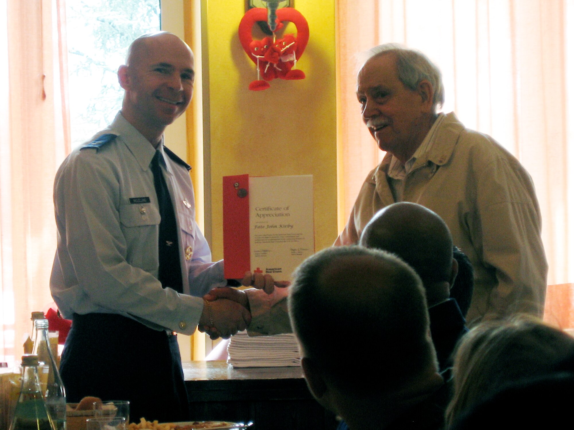Col. Patrick McClelland (left), 31st Fighter Wing vice commander, presents Fate John Kirby with an American Red Cross Certificate of Appreciation April 5. (U.S. Air Force photo/Airman LaVel Sterling)
