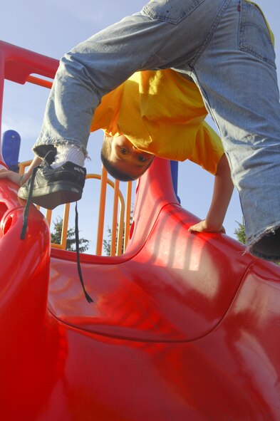 MINOT AIR FORCE BASE, N.D. -- Tejas Navickas, 9, takes advantage of the warm weather April 5 to get in some time at the playground near the temporary lodging facilities. With the recent warm, dry weather, nearly all of the winter snow has melted and the base playgrounds are drying out, providing opportunities for kids and families to enjoy outdoor activities again. (U.S. Air Force photo by Laurie Arellano)