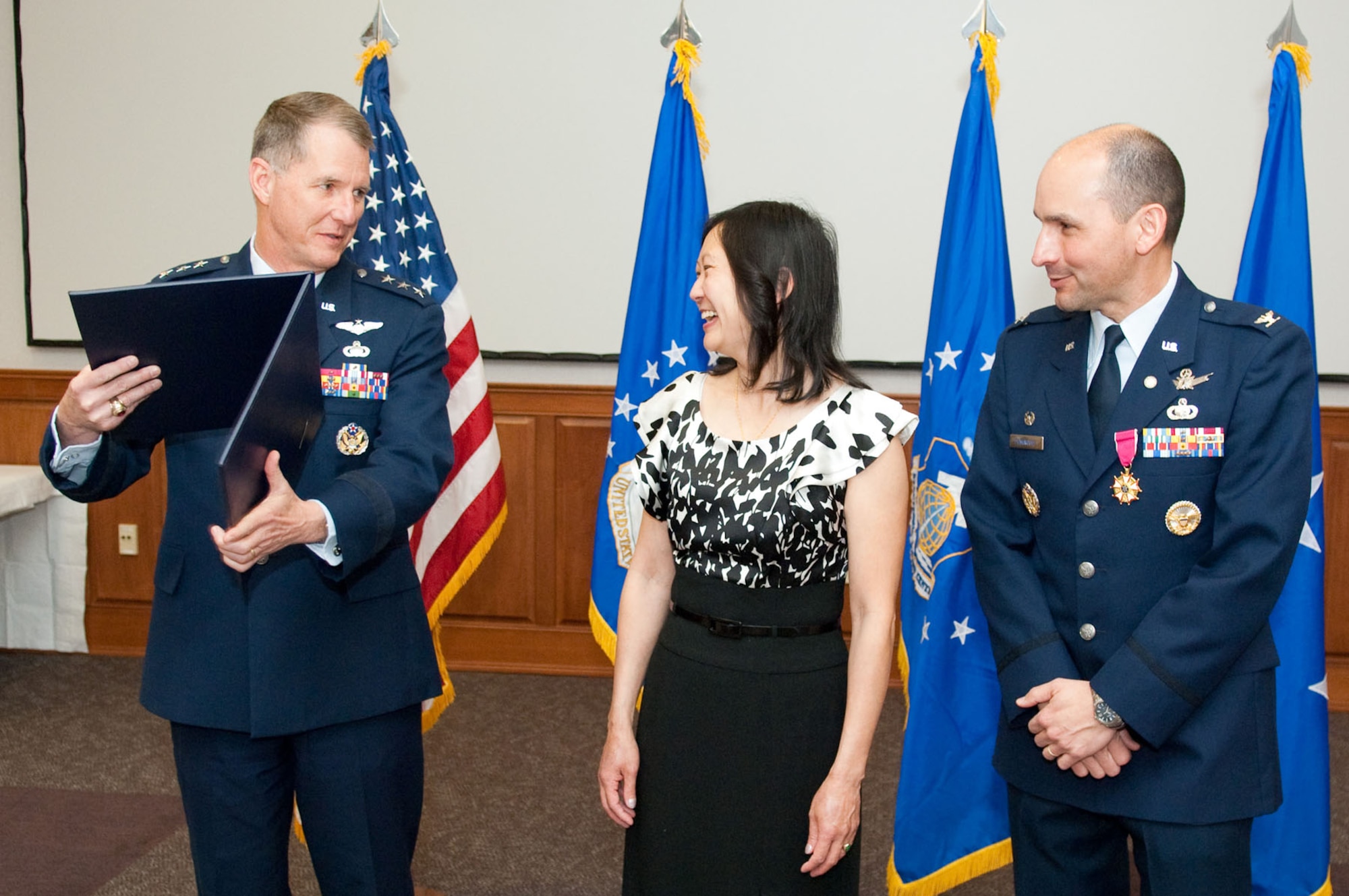 HANSCOM AIR FORCE BASE, Mass. - Electronic Systems Center commander Lt. Gen. Ted F. Bowlds (left) prepares to present Col. Robert A. Dominguez’s wife, Christina, with a certificate of appreciation during his retirement ceremony on April 2. Colonel Dominguez, 350th Electronic Systems Wing commander retires after more than 25 years of Air Force service. (U.S. Air Force photo by Rick Berry)