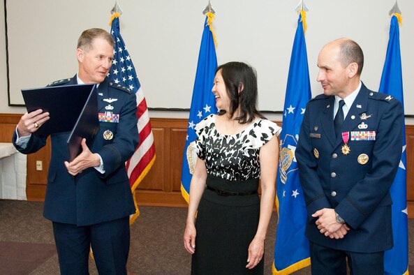 HANSCOM AIR FORCE BASE, Mass. - Electronic Systems Center commander Lt. Gen. Ted F. Bowlds (left) prepares to present Col. Robert A. Dominguez’s wife, Christina, with a certificate of appreciation during his retirement ceremony on April 2. Colonel Dominguez, 350th Electronic Systems Wing commander retires after more than 25 years of Air Force service. (U.S. Air Force photo by Rick Berry)