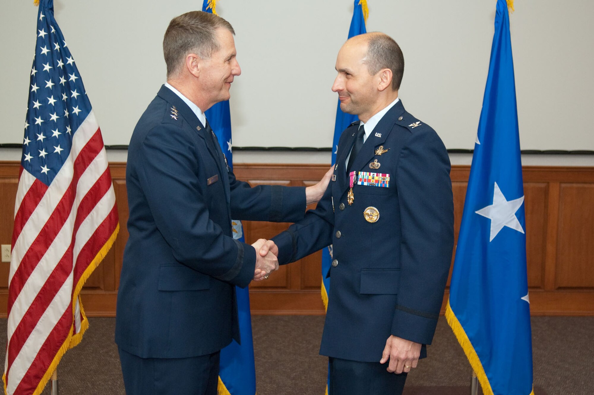 HANSCOM AIR FORCE BASE, Mass. - Electronic Systems Center commander Lt. Gen. Ted F. Bowlds congratulates Col. Robert A. Dominguez (right), commander of the 350th Electronic Systems Wing, during his retirement ceremony on April 2. Colonel Dominguez retires after more than 25 years of Air Force service. (U.S. Air Force photo by Rick Berry)