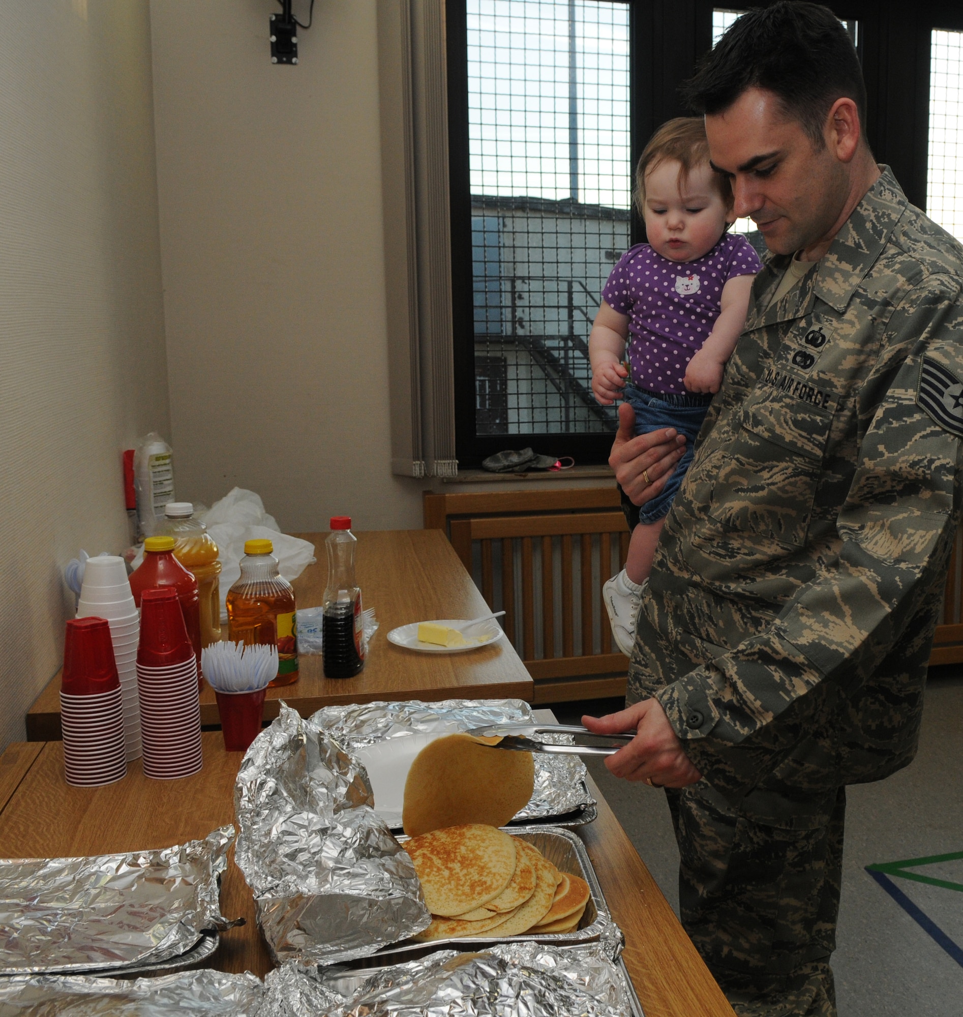 SPANGDAHLEM AIR BASE, Germany – Tech. Sgt. Douglas Witham, 52nd Fighter Wing chaplain assistant, and his daughter, Genevieve, fill a plate at the Sexual Assault Awareness Month pancake breakfast April 6. Money collected at the breakfast will benefit sexual assault victims in the Eifel region. (U.S. Air Force photo/Airman 1st Class Staci Miller)