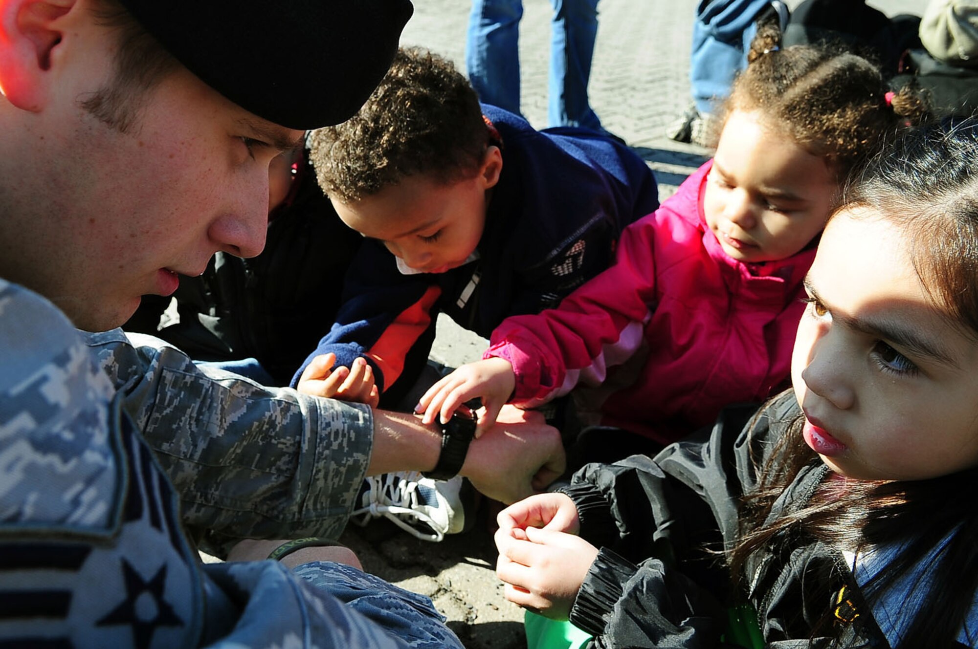 U.S. Air Force Senior Airman Joseph Schermetzkr, Tactical Air Control Party, 2nd Air Support Operations Squadron, has a captivated audience as he shows children his special watch and other tools he uses for his job during the child development center's "Boot Camp Week", Rose Barracks, Vilseck Military Community, Germany, April 7, 2010. Members of the squadron participated in the "Boot Camp Week" which gave servicemember's children an opportunity to experience some military norms such as physical training, first aid, land navigation and tactical vehicle familarization in support of the Department of Defense's Month of the Military Child?. (U.S. Air Force photo by Senior Airman Tony R. Ritter)