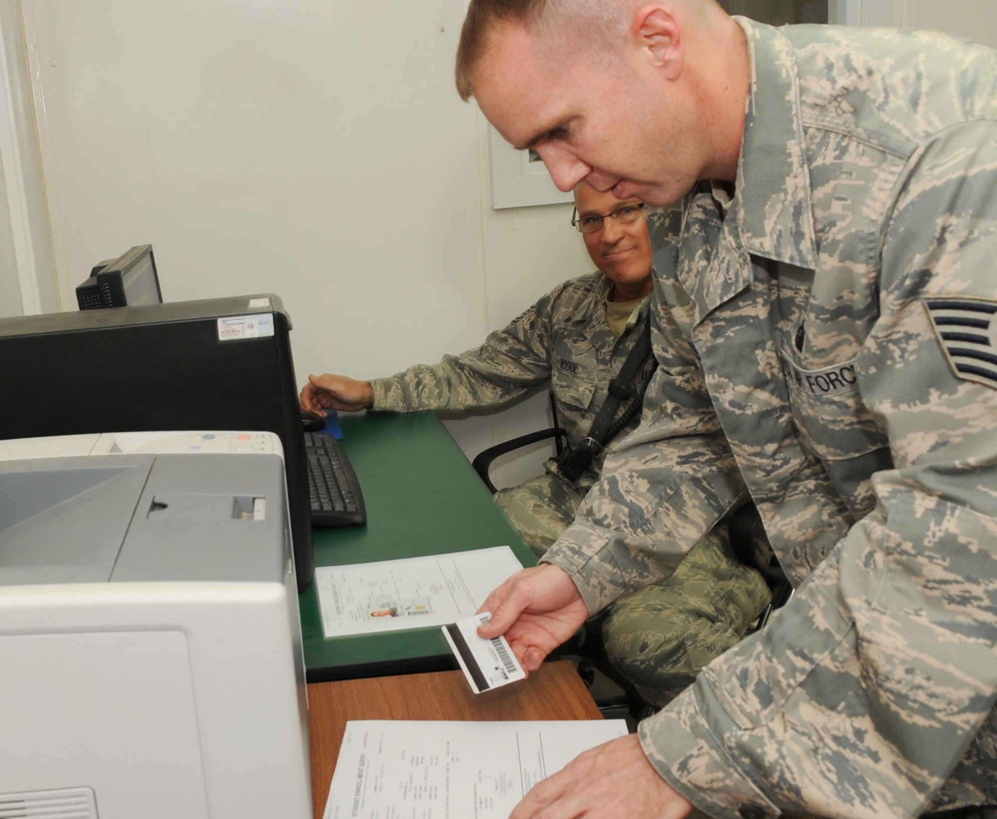 Tech. Sgt. Thomas Dotson, 506th Expeditionary Force Support Squadron test control officer, verifies identification before administering an electronic exam at the Learning Resource Center at Kirkuk Regional Air Base, Iraq on April 7, 2010.  The center offers development courses, professional military education services, various DANTES and college level entrance examinations.  Sergeant Dotson is deployed from Eielson AFB, Alaska.  (U.S. Air Force photo/Staff Sgt. Tabitha Kuykendall/Released)