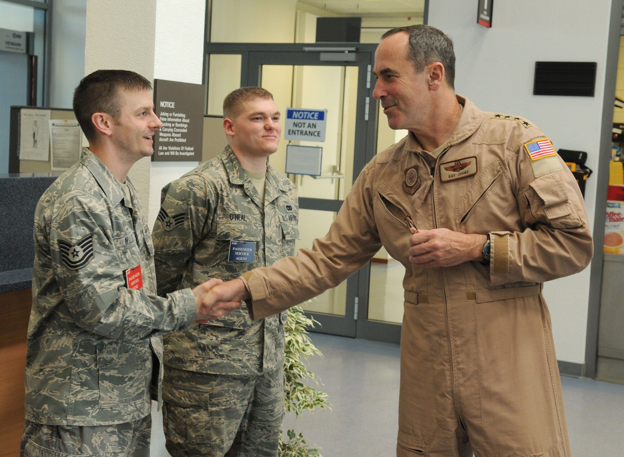 SPANGDAHLEM AIR BASE, Germany -- Gen. Ray Johns Jr., commander of Air Mobility Command, presents a coin to Tech. Sgt. Steven Miller, 726th Air Mobility Squadron passenger terminal NCO in-charge, April 6. Sergeant Miller was recognized for receiving a distinguished graduate award while attending NCO academy. (U.S. Air Force photo/Senior Airman Nathanael Callon) 