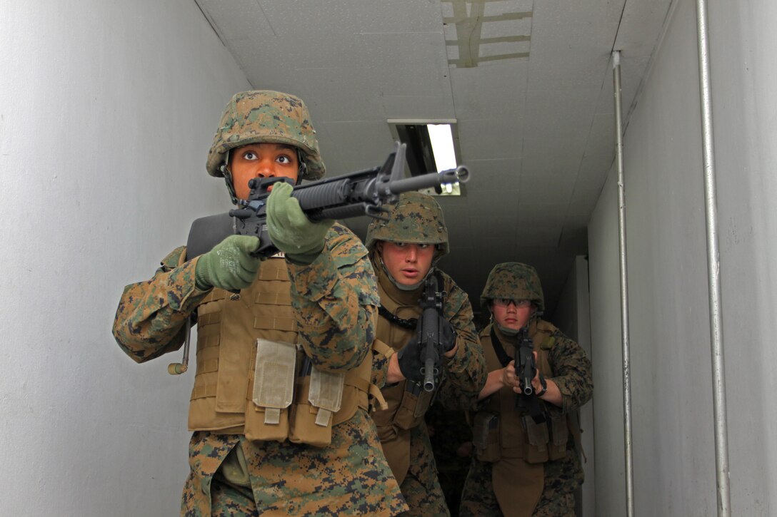 YECHON AIR BASE, Republic of Korea - (From left to right) Cpl. Arielle Coleman, combat engineer with Marine Wing Support Squadron 171, name, job title, and name, job title, move down the hall of an abandoned building here during military operations in urban terrain training April 9. Marines participating in Exercise Foal Eagle 2010 trained with the Republic of Korea Air Force in MOUT for approximately one week.