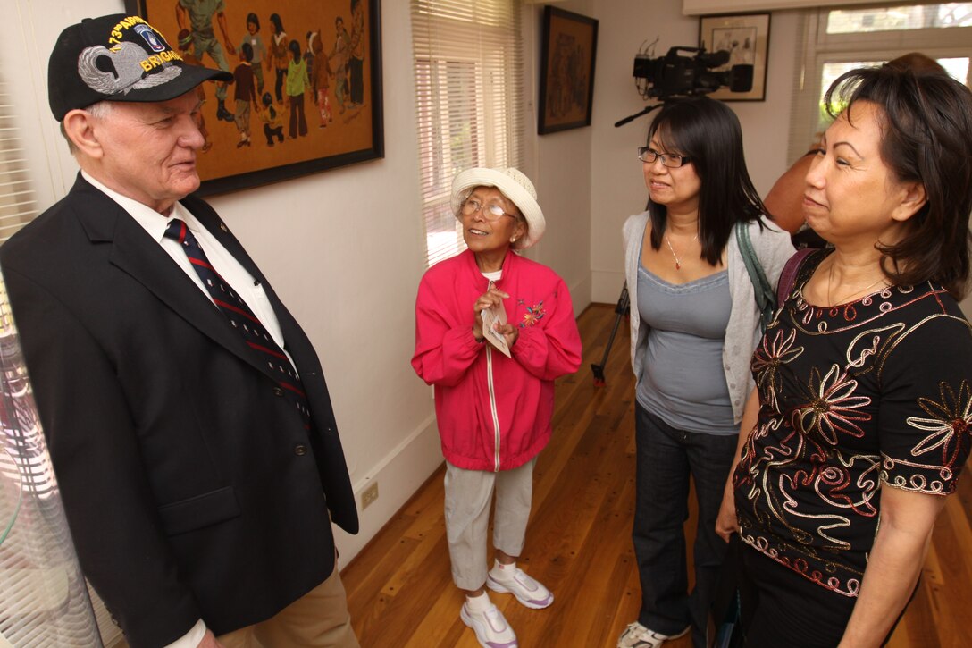 Retired Gunnery Sgt. Lewis D. Beatty (left), talks with Vietnam War survivors during the opening of Camp Pendleton’s "Images at War's End" exhibit at the Santa Margarita Ranch House, April 8. After the fall of Saigon in 1975, nearly half of the 130,000 Vietnamese refugees that resettled in America passed through the gates of Camp Pendleton. Thirty-five years later, base historians are now honoring their story with the museum exhibit, a 36-photo display that commemorates the lives of those who fled North Vietnamese communist oppression.