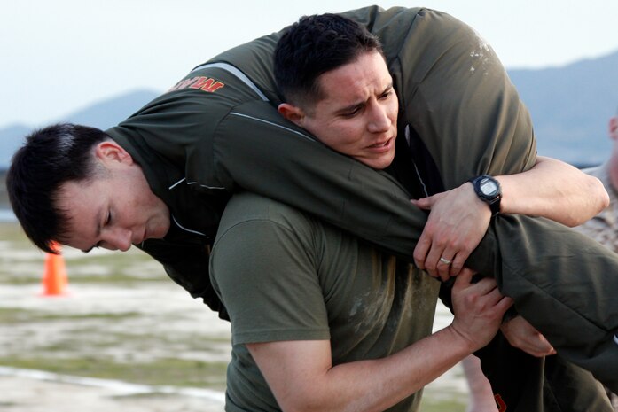 Sgt. Ricardo Gomez, station combat camera production chief, fireman carries Sgt. James Hardenbrook, a station property supply administration chief, at Penny Lake field here during a combined physical fitness and combat fitness test competition April 8. Both Marines and Sgt. Adam Kruse, station outside plant chief, competed for the chance to participate in a tandem parachute jump during jump rehearsals prior to Friendship Day on May 5.
