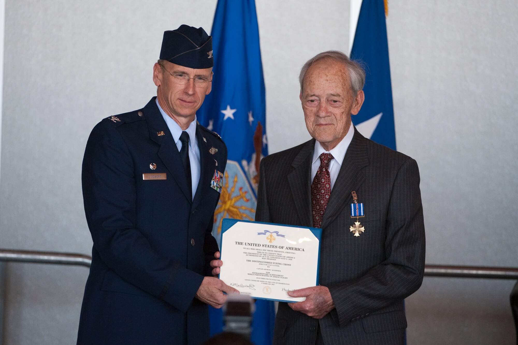 HOLLOMAN AIR FORCE BASE, N.M. --  Col. Donald Lindberg, 44th Fighter Group commander, presents the Distinguished Flying Cross to Retired Capt. Arthur Kleiderer April 9, 2010, for distinguished service as group lead pilot for the 44th Bomb Group during 14 combat missions near the conclusion of World War II. The 44th Fighter Group traces its lineage to the famed WWII 44th Bombardment Group (Heavy) originally activated in January 1941 at MacDill Army Air Field in Tampa, Fla., and flew the then state-of-the-art B-24 Liberator. Sixty-nine years later, the 44th Fighter Group is the only Air Force Reserve organization to be selected to fly the U.S. Air Force's premier air superiority fighter, the F-22 Raptor. (U.S. Air Force photo by Staff Sgt. Joe Laws / Released)