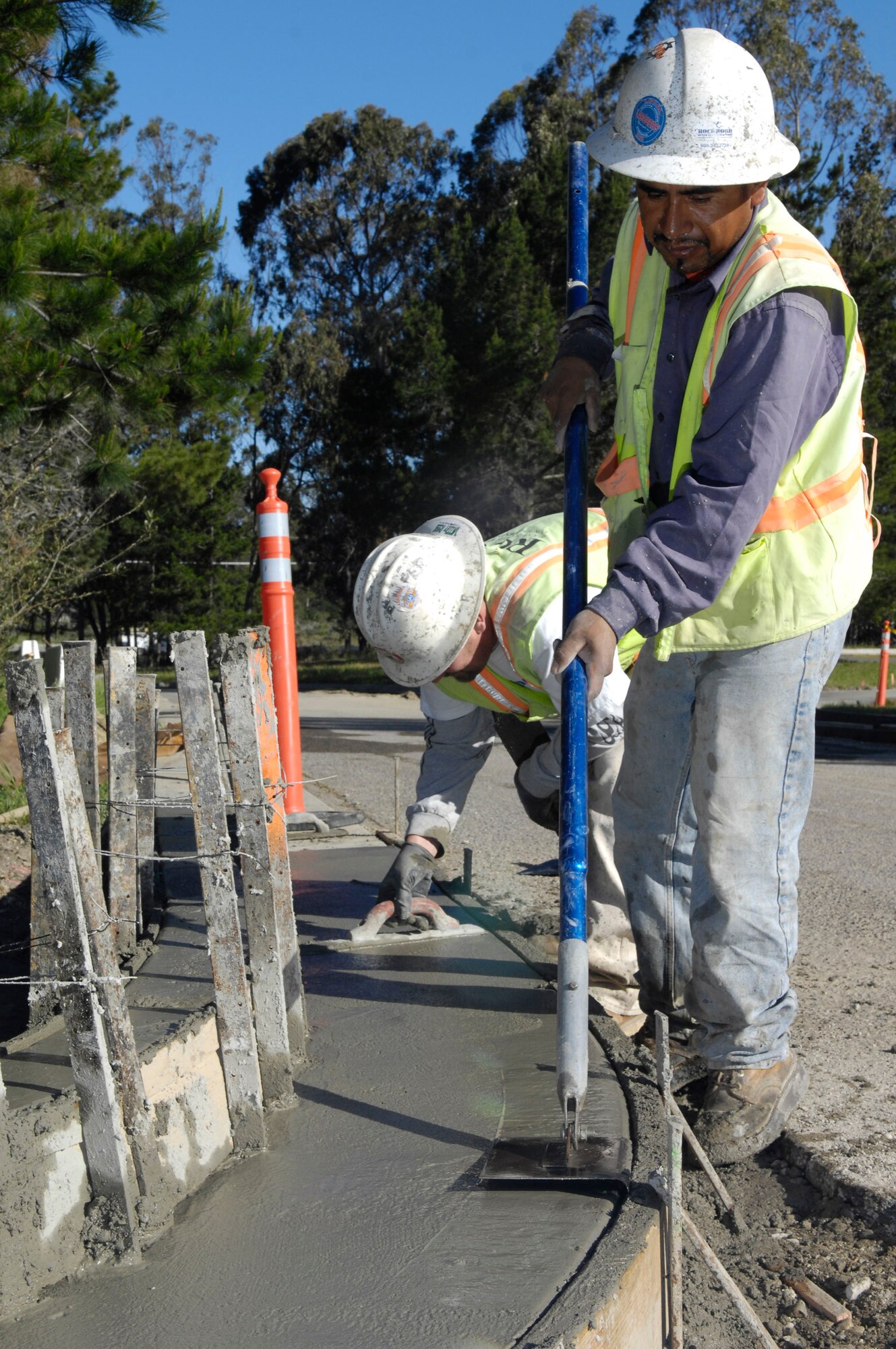 VANDENBERG AIR FORCE BASE, Calif.  – Ismael Maldonado lines out the curve as Donny Snyder smoothes out the freshly poured concrete at the 30th Space Communications Squadron here Thursday, April 8, 2010.  Rockwood Construction was awarded the contract to make some much needed repairs to the parking lot and to give a facelift to add a more modern design. (U.S. Air Force photo/Staff Sgt. Scottie T. McCord)