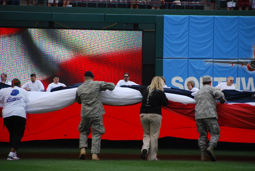 301st Fighter Wing members and guests unfurled a 100'x300' American flag in the outfield as well as a large Texas flag before the National Anthem during the home opener for the Texas Rangers baseball club April 5. Members of the 301st Fighter Wing participated in nearly every part of the pre-game festivities. Most of the participants stayed to watch the Rangers defeat the Toronto Blue Jays 5-4  (U.S. Air Force photo/TSgt Shawn David McCowan)