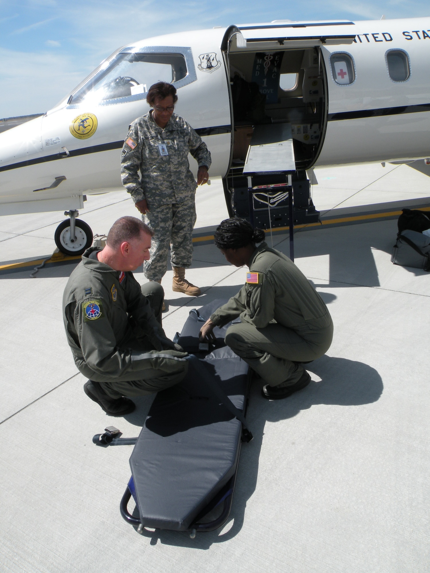 A medical team prepares a table for a patient’s arrival at MacDill Air Force Base, Fla. March 8, 2010. The patient will be transferred to the table which is then loaded in the aircraft on a slide and onto a special medical sled. This, part of the first ever aeromedical evacuation mission for the 103rd Airlift Wing, Conn. Air National Guard. The Flying Yankee C-21s picked up patients as they arrived from overseas as well as those needing transfer from other CONUS medical facilities. (U.S. Air Force Photo by Maj. Christopher P. Papa, photo was altered for security purposes)