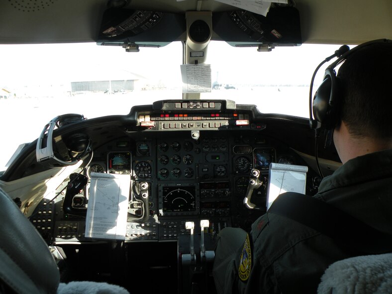 Maj. Stephen R. Gwinn, C-21 pilot, 118th Airlift Squadron, completes pre-flight checks in the cockpit of a C-21A Cougar as patients are unloaded from a C-17 Globemaster in the background before flying the unit’s first aeromedical evacuation mission March 6, 2010, at Scott Air Force Base, Ill. Connecticut's Flying Yankee C-21s picked up patients as they arrived from overseas as well as those needing transfer from other CONUS medical facilities. (U.S. Air Force photo by Maj. Christopher P. Papa)