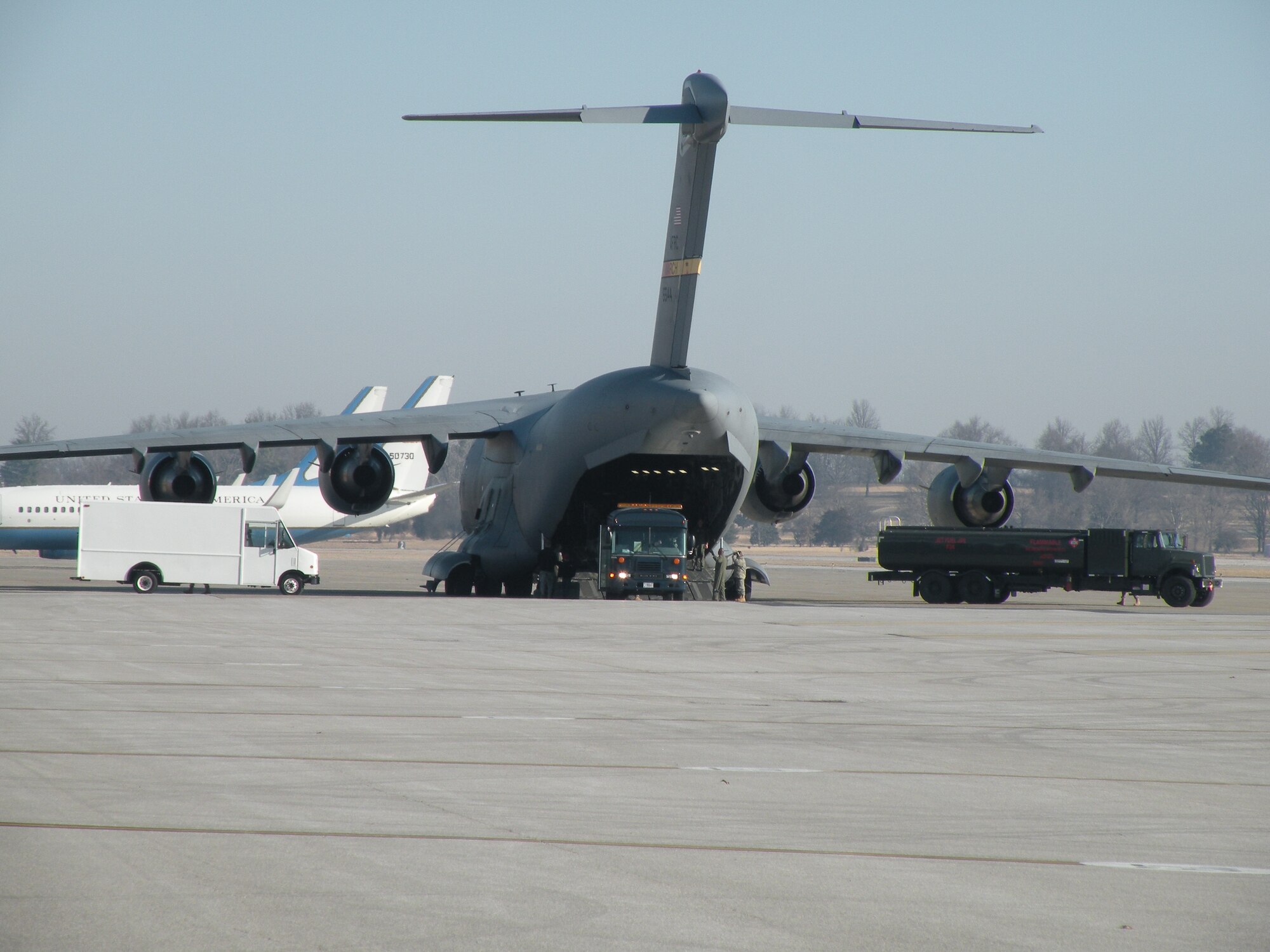Patients are offloaded from an arriving C-17 Globemaster and into waiting vehicles on the flightline at Scott Air Force Base March 6, 2010. Two ambulatory patients from this flight were loaded into a waiting C-21A aircraft marking the historic first aeromedical evacuation flight for the 103rd Airlift Wing, Conn. Air National Guard. (U.S. Air Force photo by Maj. Christopher P. Papa)