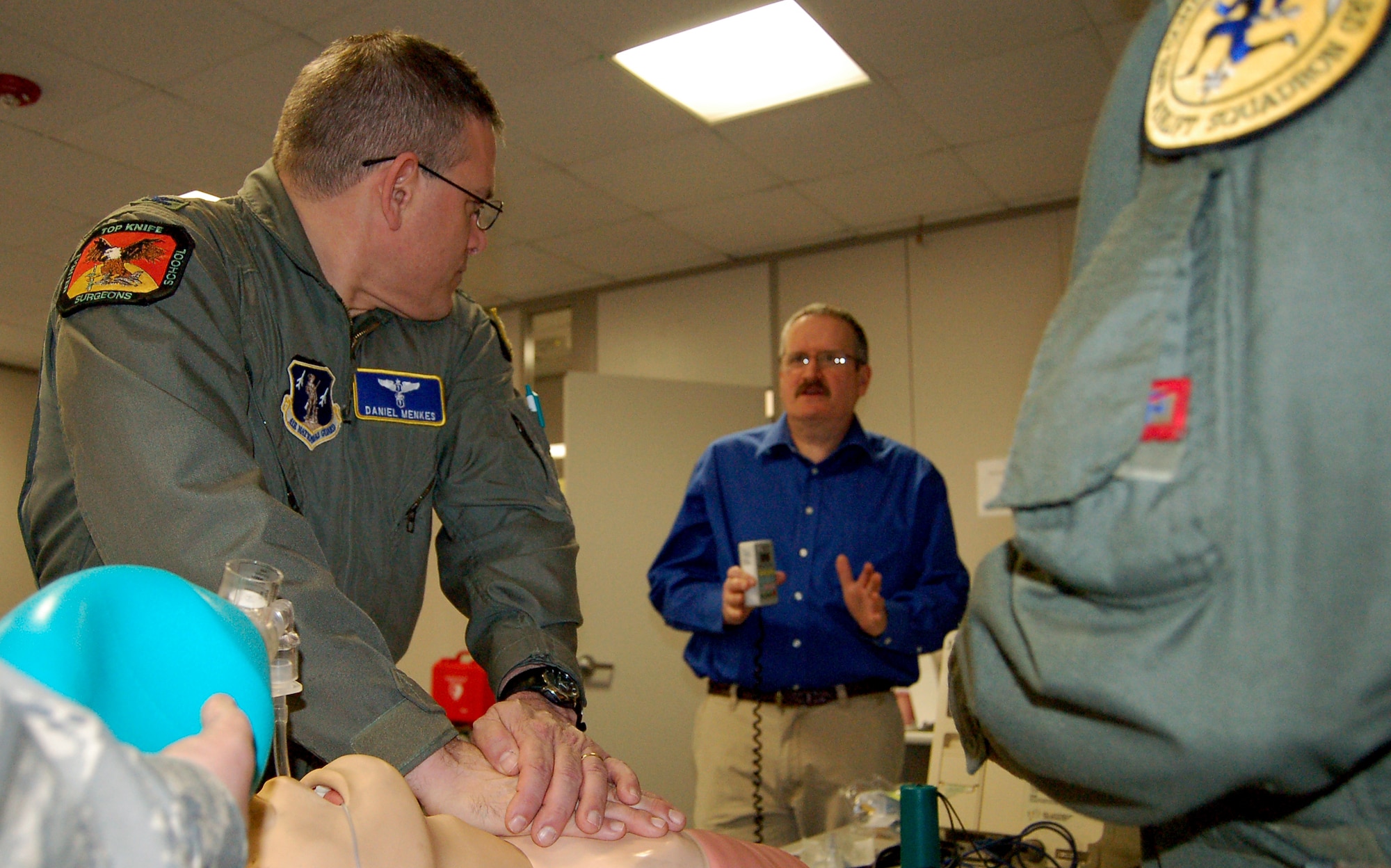 Col. Daniel Menkes, chief of aerospace medicine with the 103rd Medical Group, Conn. Air National Guard, stops chest compressions to receive new instructions from instructor Bruce Moore, retired Lt. Col chief nurse from the 104th Medical Group at Barnes Air National Guard Base, Mass.  Moore evaluated 103rd medical providers for qualification in advanced cardiac life saving. (U.S. Air Force photo by Tech. Sgt. Joshua Mead)
