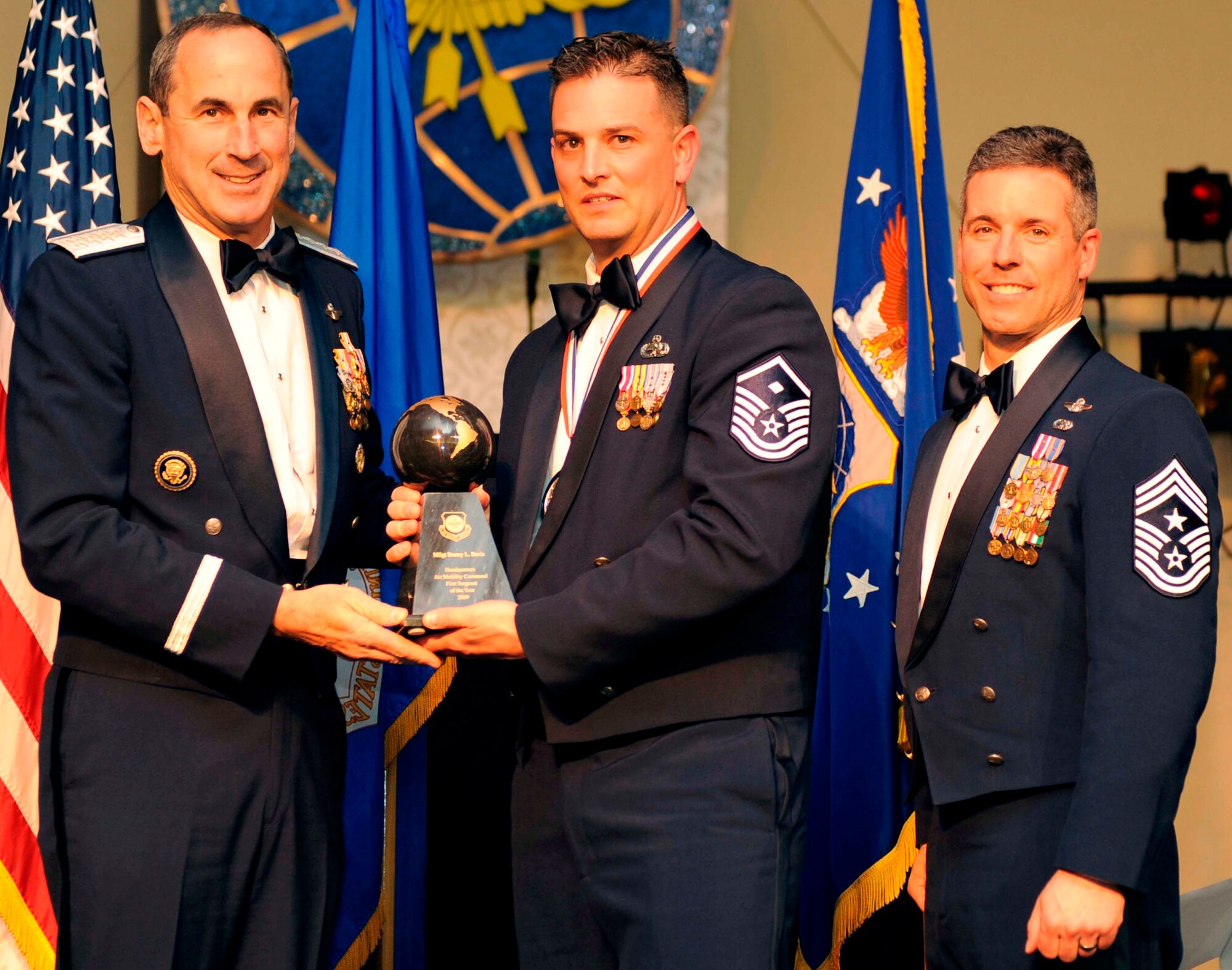Master Sgt. Danny L. Davis, of the 43rd Airlift Wing, Pope AFB, N.C.., is awarded 2009 Air Mobility Command First Sergeant of the Year by AMC Commander, Raymond E. Johns, and AMC's Command Chief, Chief Master Sgt. David Spector at an award ceremony at Scott Club on Scott Air Force Base, Ill. 