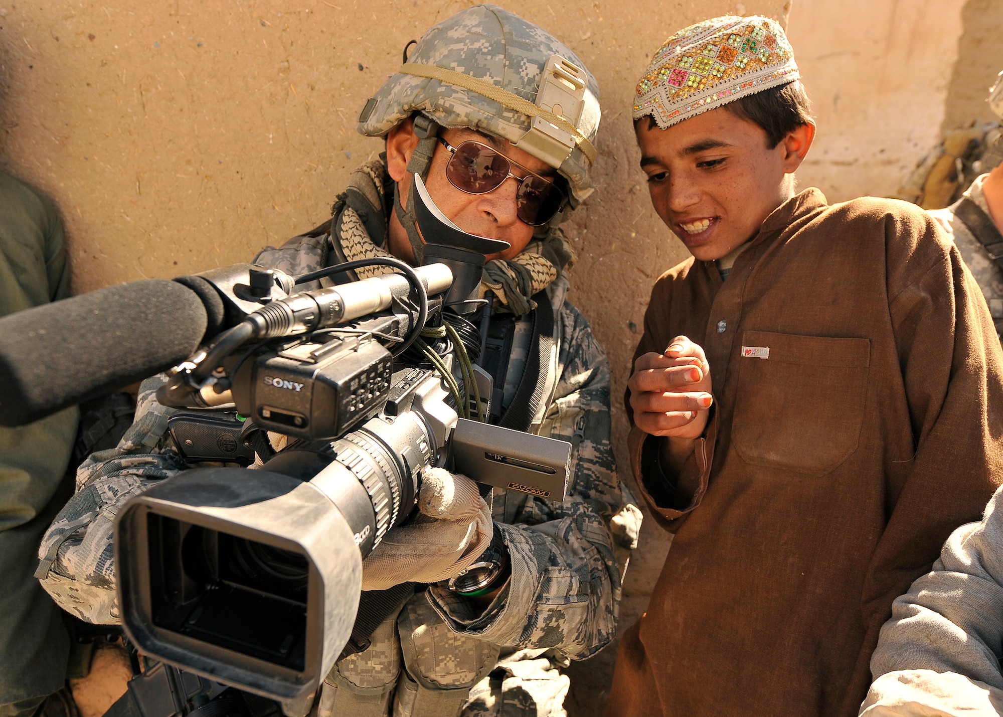 Master Sgt. Robert Carreon shows an Afghan student his footage Jan. 7, 2010, at the Bazaar school in Hutal, Afghanistan. Sergeant Carreon is a videographer with 4th Combat Camera and was attached to the 5th Brigade, 2nd Infantry Division. (U.S. Air Force photo/Staff Sgt. Dayton Mitchell) 