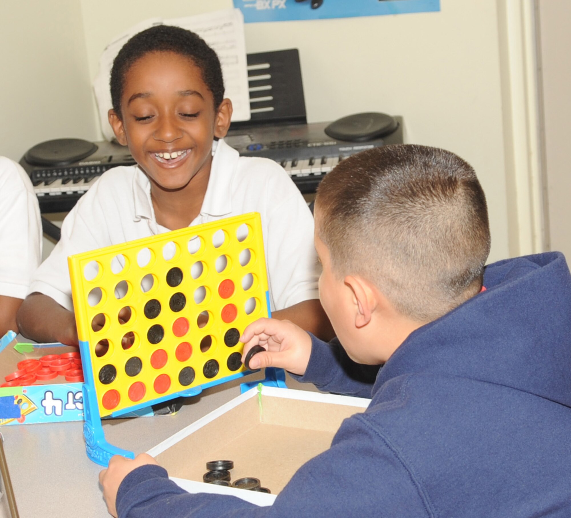 BARKSDALE AIR FORCE BASE, La. – Brandon Moore (left), 9, son of Tech. Sgt. Eddie Moore, 608th Air Force Network Operations Center, and Alan English, 9, son of Staff. Sgt. Maria English, 2d Force Support Squadron, play Connect Four after school as they wait for their parents to get off work. (U.S. Air Force photo by Senior Airman Alexandra M. Longfellow) (RELEASED)