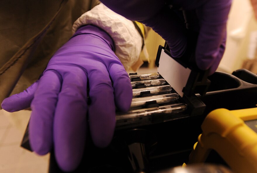 MOODY AIR FORCE BASE, Ga. -- Airmen 1st Class Jennifer Forsythe, 23rd Aeromedical Dental Squadron bioenvironmental journeyman, uses a razor to cut tubes filled with chemical-based substances during the Air Combat Command Chemical, Biological, Radiological and Nuclear Challenge here April 6. The kit is used to test the air for the chemical threat after completing 50 pumps above the affected area. (U.S. Air Force photo by Airman 1st Class Joshua Green/RELEASED)