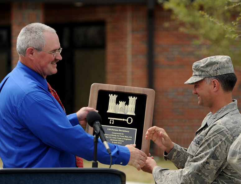MOODY AIR FORCE BASE, Ga. -- Bryan Doak, U.S. Army Corps of Engineers project engineer, presents Col. William DeMaso, 23rd Wing vice commander, with a plaque during a ribbon-cutting ceremony celebrating the completion of a new base dormitory here April 8. The new dorm was funded by the Base Closure and Realignment Commission, costing nearly $16 million. (U.S. Air Force photo by Airman Class Joshua Green)  