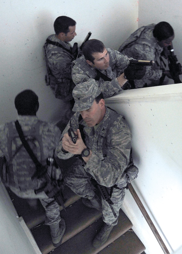 Colonel Steven Shepro, Joint Base Andrews/316th Wing commander, watches the top of the stairwell while Airmen from the 316th Security Forces Squadron move up to the second floor during combat skills training April 6, 2010, at Joint Base Andrews, Md. Colonel Shepro and several others participated in the field training portion of the five-day course to understand the qualifications 316 SFS Airmen are required to meet before they deploy. (U.S. Air Force photo by Airman 1st Class Perry Aston)