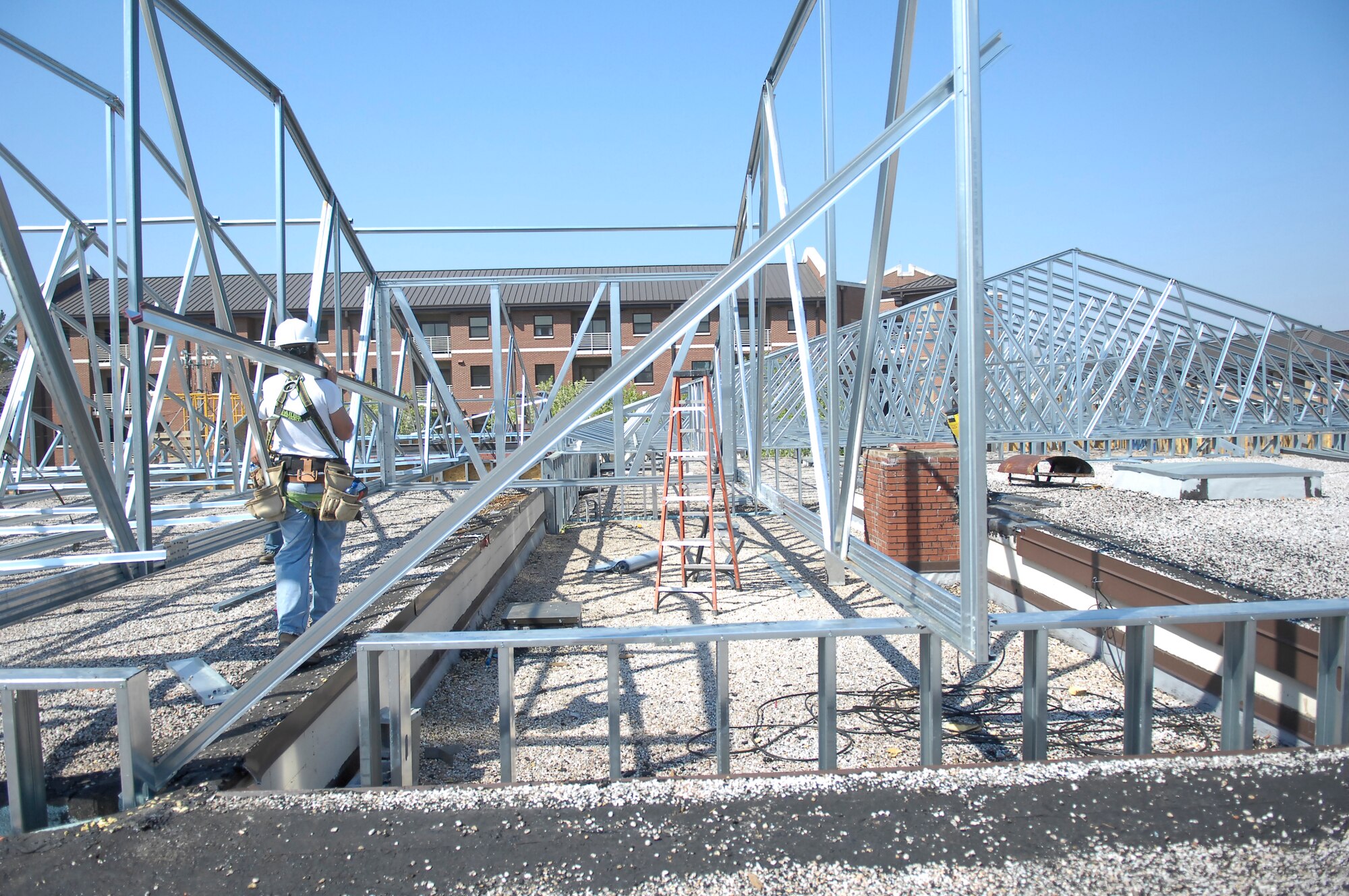 Construction workers set bracing and trusses to construct the roof on the future Airmen Center April 4. Construction plans for the center include a dance floor, post office, refurbished bar, Internet Café and a Day Room as well as wire and wireless Internet connection. The center is scheduled to open in 2011. (U.S. Air Force Air Force Photo/ 2nd Lt. Cammie Quinn)