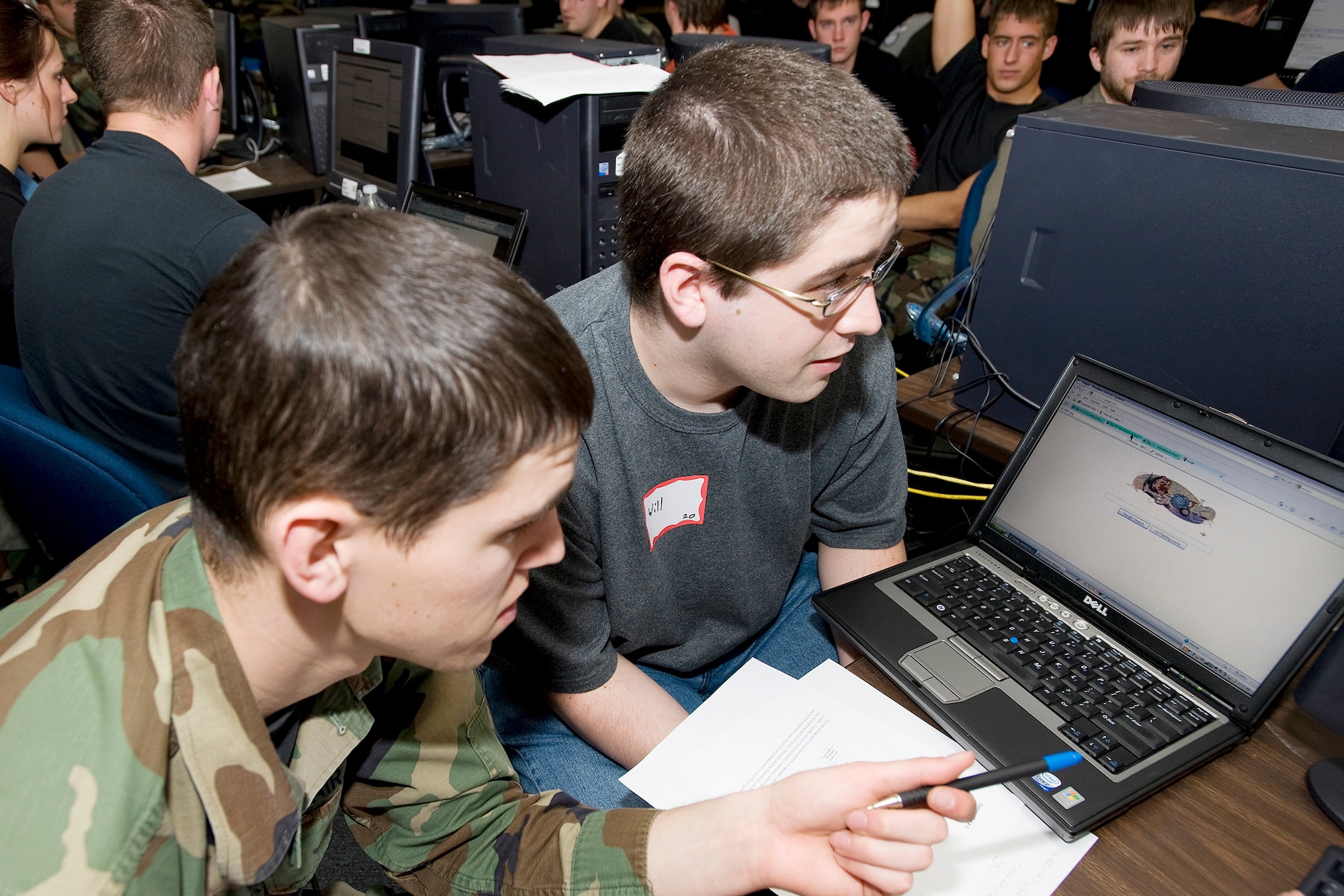 U.S. Air Force Academy Cadet 1st Class Bryan Hanes and Will Mitchell, a local student, participate in the Computer and Network Vulnerability Assessment Scenario April 2, 2010 at the Academy, Colo. Scenarios challenged students to hunt down and identify weaknesses in system design and implementation for a fictional social networking Web site. (U.S. Air Force photo/Bill Evans)