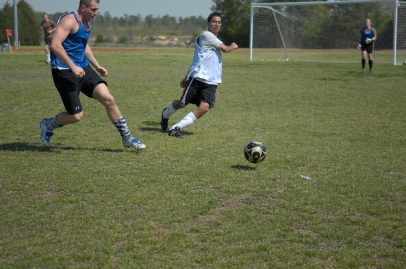 Airman 1st Class Deaven Randolph, 43rd Comptroller Squadron and Senior Airman Lee Ford, 43rd Aerial Port Squadron, race to take control of the ball during a soccer game April 6. The 43rd CPTS meet throughout the week to conduct PT.  (U.S. Air Force Photo/ 2nd Lt. Cammie Quinn)