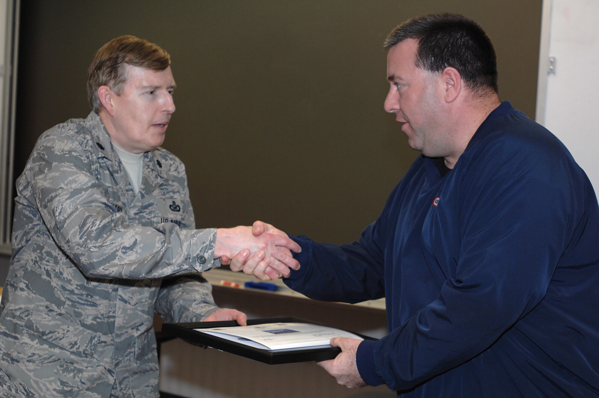 GRISSOM AIR RESERVE BASE, Ind., -- Lt. Col. Gary Lockard, 434th Air Refueling Wing public affairs chief, presents Bradley Rauchfuss with a plaque from the Employer Support of the Guard and Reserve as well as an honorary aircrew certificate after an employer flight held here April 7. Mr. Rauchfuss, along with other employers of Grissom reservists visited the base to get a firsthand look at the 434th ARW as well as an aerial refueling mission. (U.S. Air Force photo/Tech. Sgt. Mark R. W. Orders-Woempner)